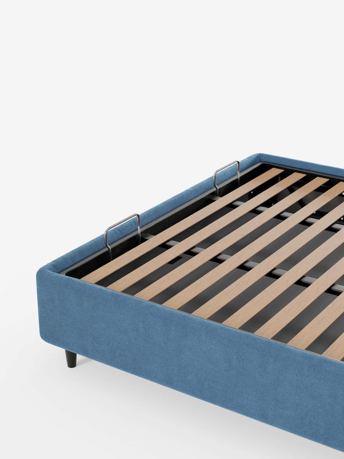 Un letto sommier imbottito ERON con vano contenitore in tessuto impermeabile certificato Oeko-Tex, in tessuto blu con vano contenitore a vista, dotato di base a doghe in legno e struttura in metallo nero su sfondo bianco.