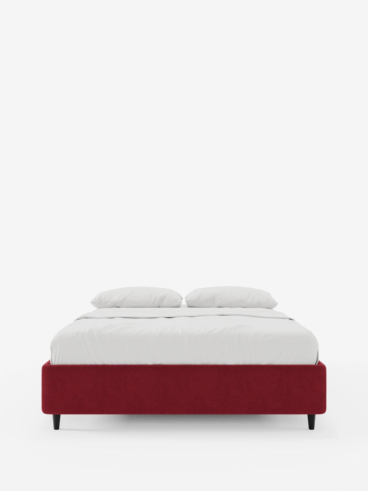Un letto ERON con rete imbottita e vano contenitore in tessuto impermeabile certificato Oeko-Tex, dal profilo ribassato, poggia su quattro piccoli piedini neri ed è rivestito con biancheria da letto candida e due cuscini coordinati, su uno sfondo bianco a tinta unita.