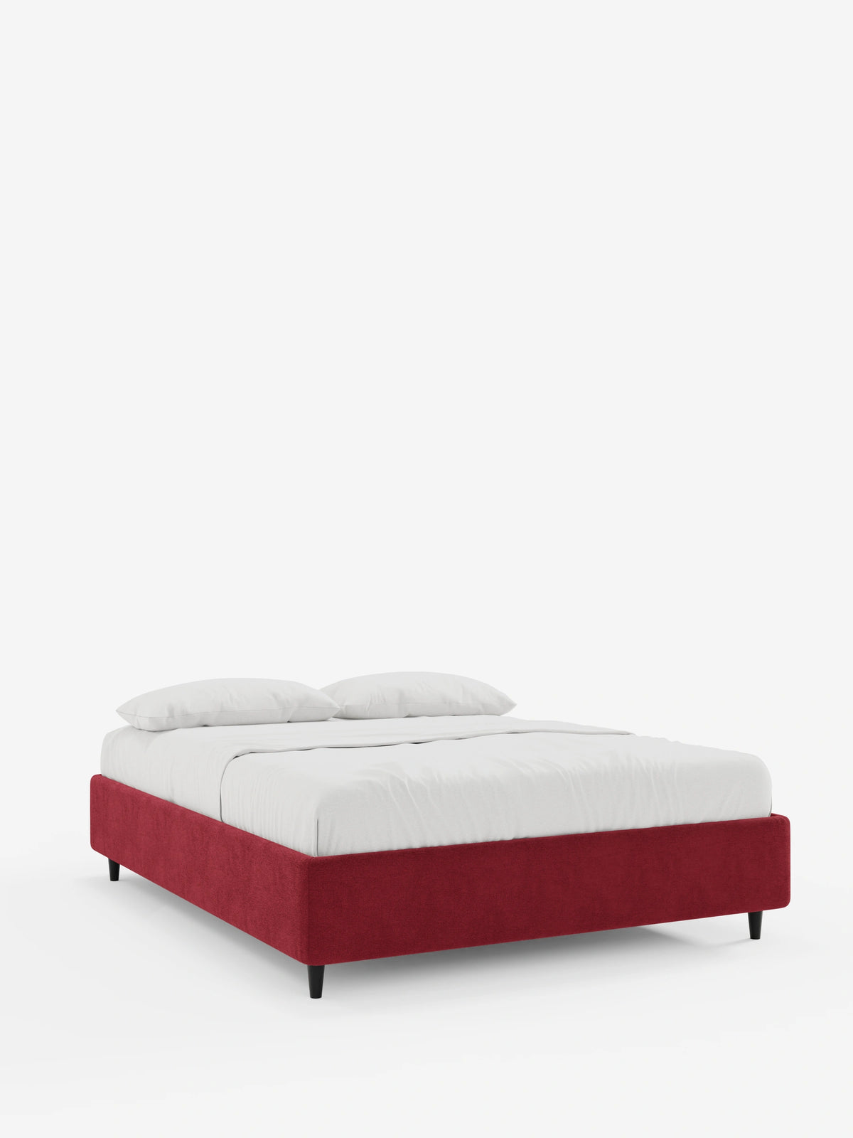 Un letto sommier ERON dal profilo ribassato, imbottito e dotato di vano contenitore, rivestito in tessuto impermeabile certificato Oeko-Tex color rosso intenso, ripreso da un’angolazione a tre quarti con base rettangolare, gambe corte nere e biancheria da letto candida con due cuscini.