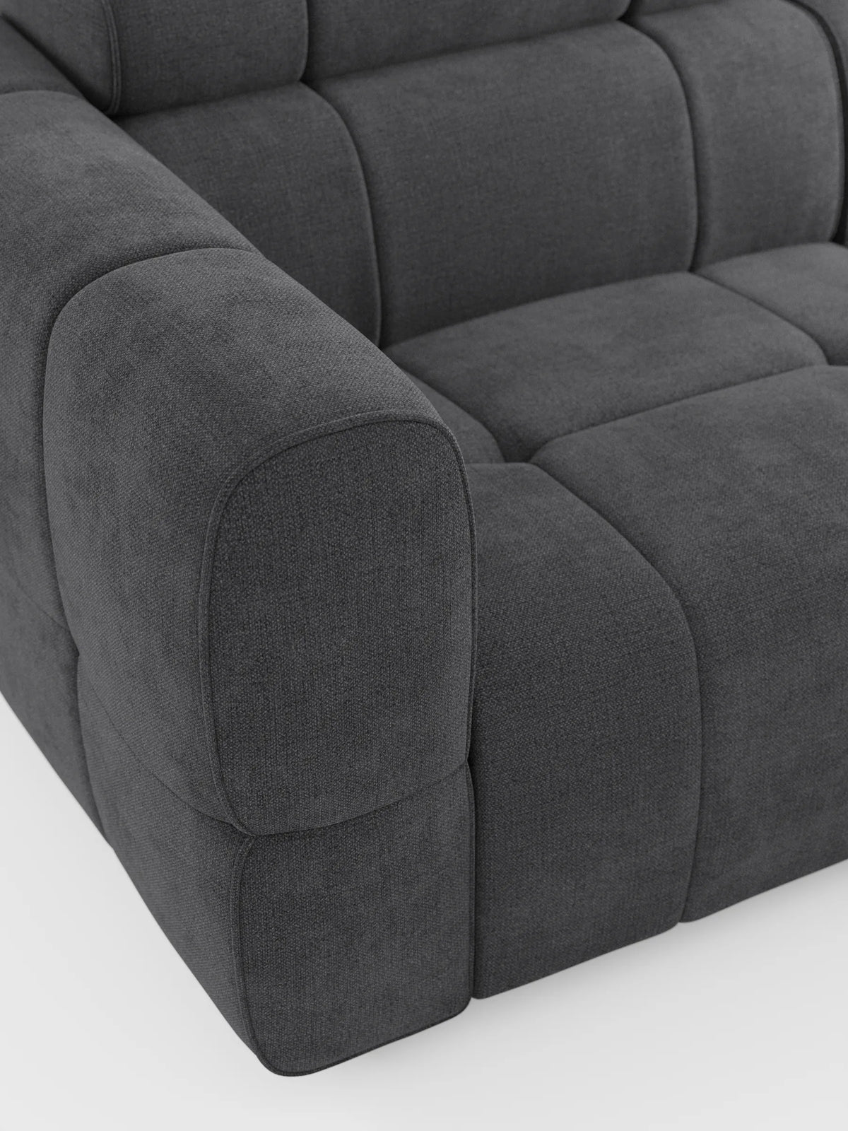 Il divano angolare modulare Giotto a 5 posti da 296 cm con penisola e funzione relax elettrica opzionale, rivestito in tessuto smacchiabile T23, è un divano modulare grigio antracite con finitura in tessuto testurizzato, cuscini squadrati e braccioli arrotondati che risaltano sullo sfondo bianco.