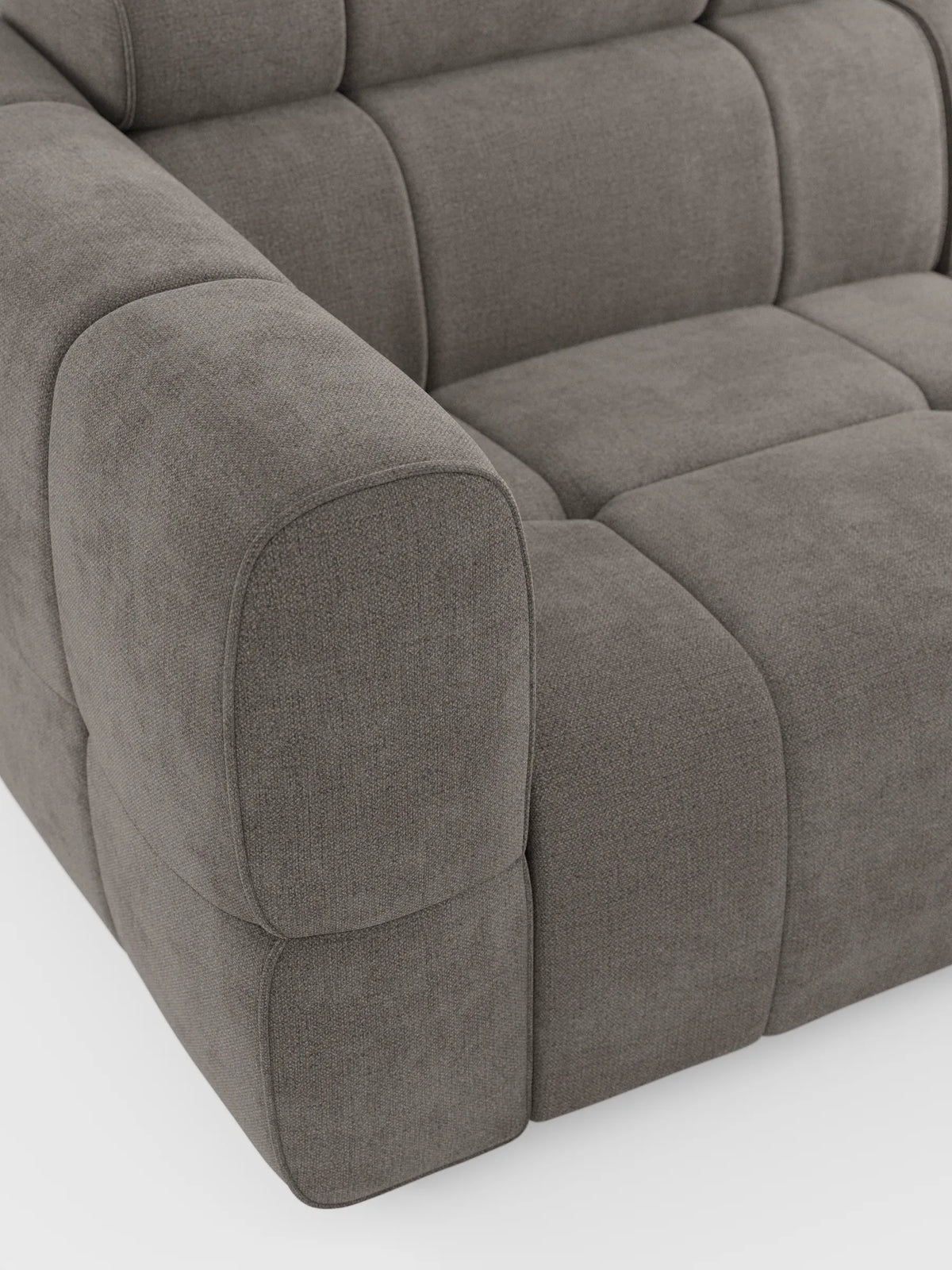 Un primo piano del divano angolare modulare Giotto color taupe a 5 posti, lungo 296 cm, con penisola e funzione relax elettrica opzionale, rivestito in tessuto smacchiabile T23, caratterizzato da bordi morbidi e arrotondati, una trama a vista e un motivo trapuntato a griglia su sfondo bianco.