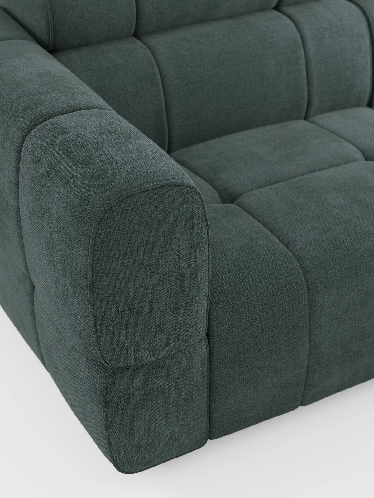 Un primo piano del divano angolare modulare Giotto a 5 posti, 296 cm, color verde acqua scuro, con penisola e funzione relax elettrica opzionale, rivestito in tessuto antimacchia T23, caratterizzato da un tessuto testurizzato, una silhouette squadrata e cuciture imbottite ben evidenti.