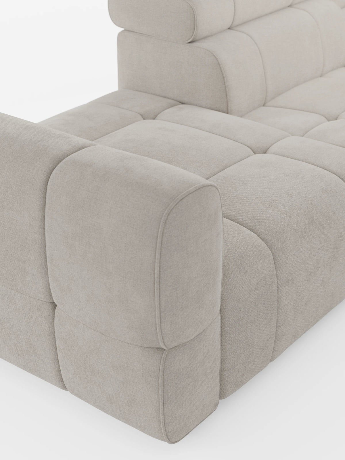 Un morbido divano componibile Giotto Divano, beige, trapuntato, con terminale aperto – opzione relax elettrico in tessuto smacchiabile T23: un divano modulare dai bordi arrotondati, con sezioni squadrate e uno schienale basso, dal design minimalista.