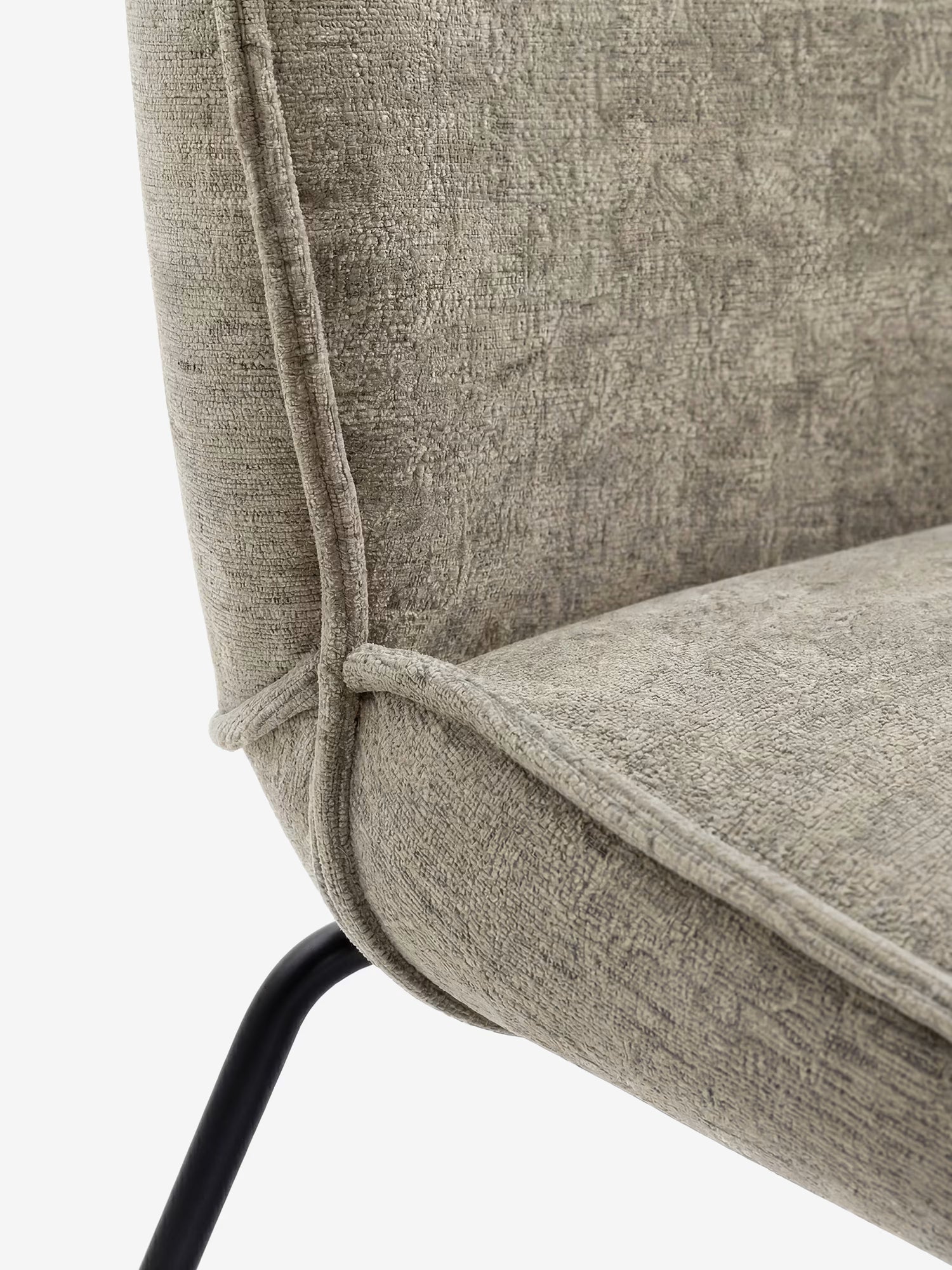 Il primo piano della sedia Iride, imbottita in morbido tessuto materico di Divani.Store, ne mette in risalto il rivestimento grigio chiaro con trama in rilievo e cuciture a vista, la seduta e lo schienale imbottiti e le eleganti gambe in metallo nero, il tutto su uno sfondo bianco a tinta unita.