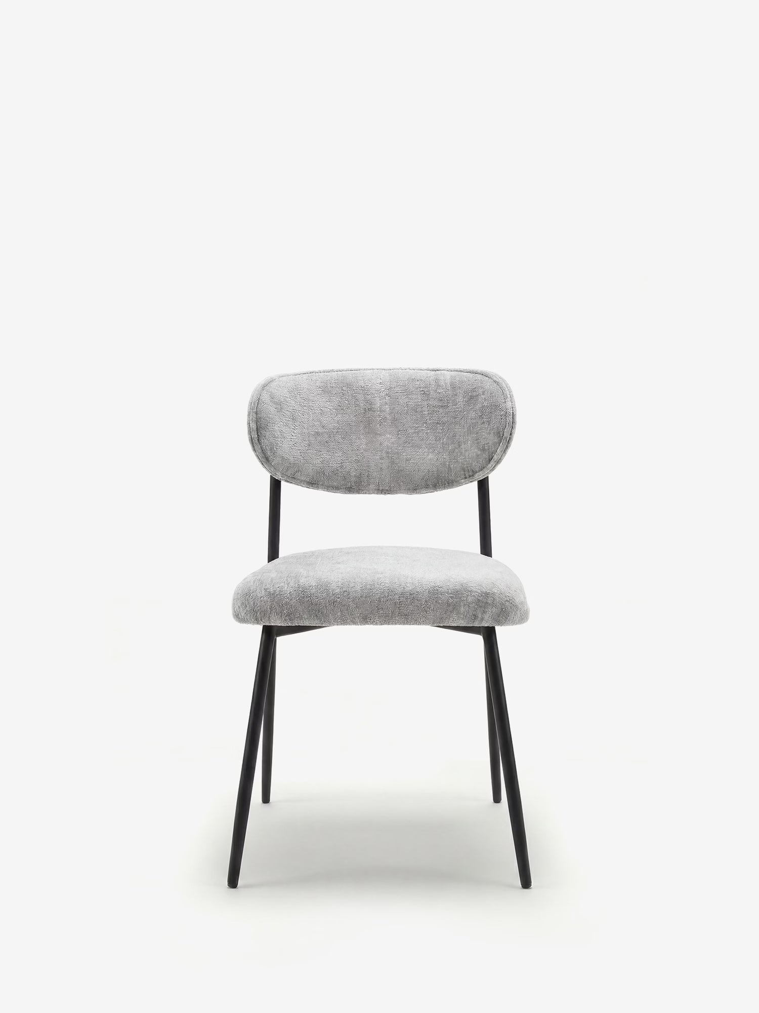 La Luce, sedia imbottita in morbido tessuto ciniglia di Divani.Store, con seduta e schienale arrotondati di colore grigio chiaro su quattro gambe in metallo nero inclinate, spicca su uno sfondo bianco per il suo design contemporaneo e minimalista.