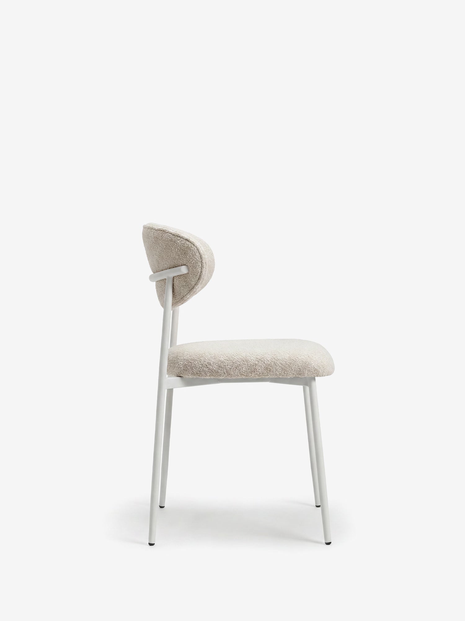 La Luce, la sedia imbottita di Divani.Store, presenta una silhouette minimalista, una seduta arrotondata e uno schienale curvo in tessuto ciniglia beige chiaro, con struttura in metallo bianco: un perfetto esempio di design contemporaneo.