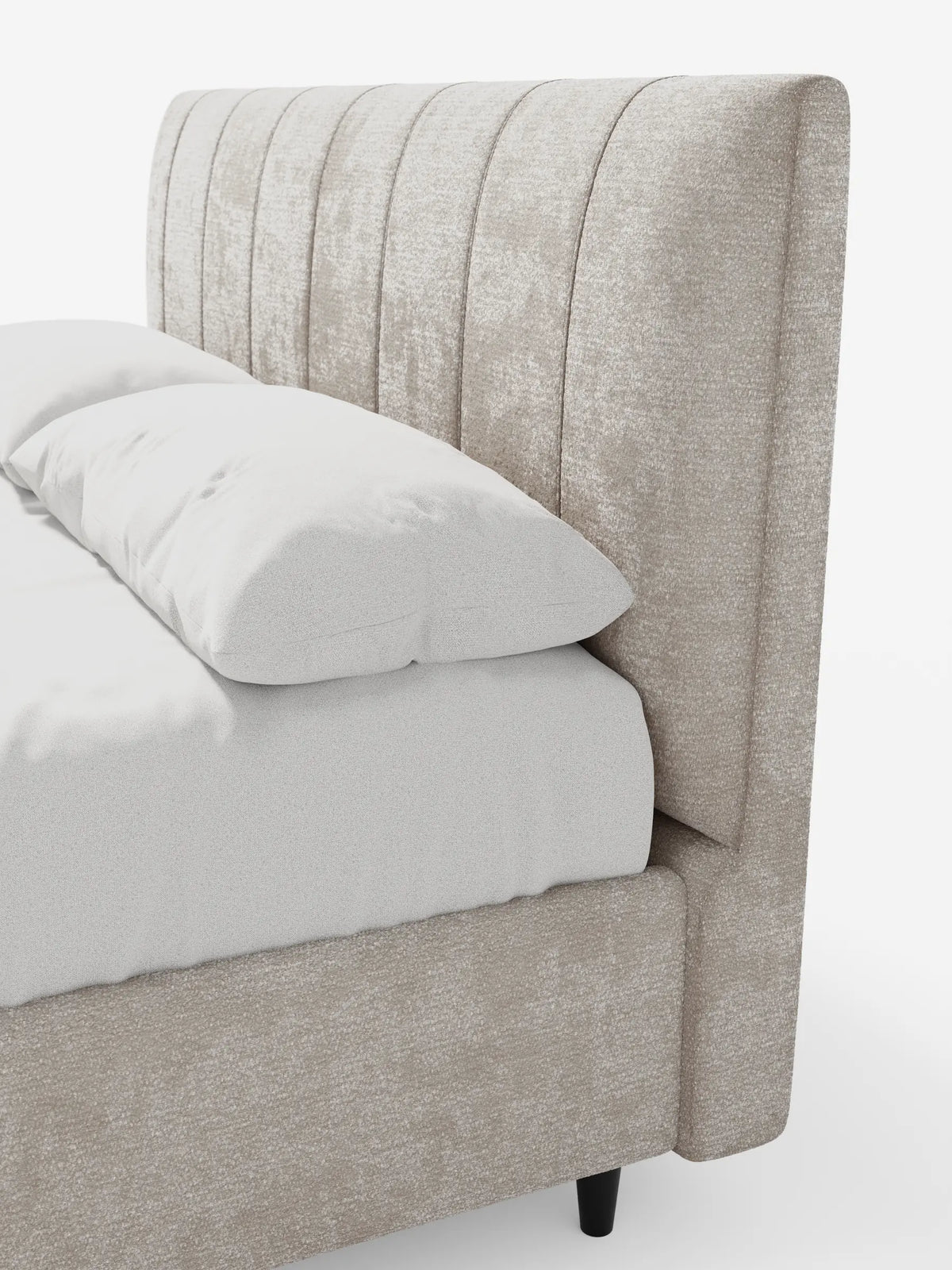 Un primo piano del letto imbottito ONYX con contenitore e testiera verticale in tessuto certificato Oeko-Tex®, caratterizzato da un'alta testiera trapuntata a canali verticali in tessuto beige chiaro, lenzuola bianche e due morbidi cuscini su uno sfondo bianco.