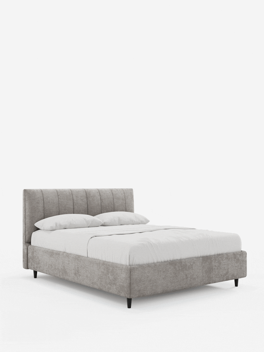 Il letto imbottito ONYX con contenitore e testiera verticale in tessuto certificato Oeko-Tex® è un letto moderno caratterizzato da una testiera verticale di colore grigio chiaro, biancheria da letto bianca e gambe corte, scure e affusolate su uno sfondo bianco.