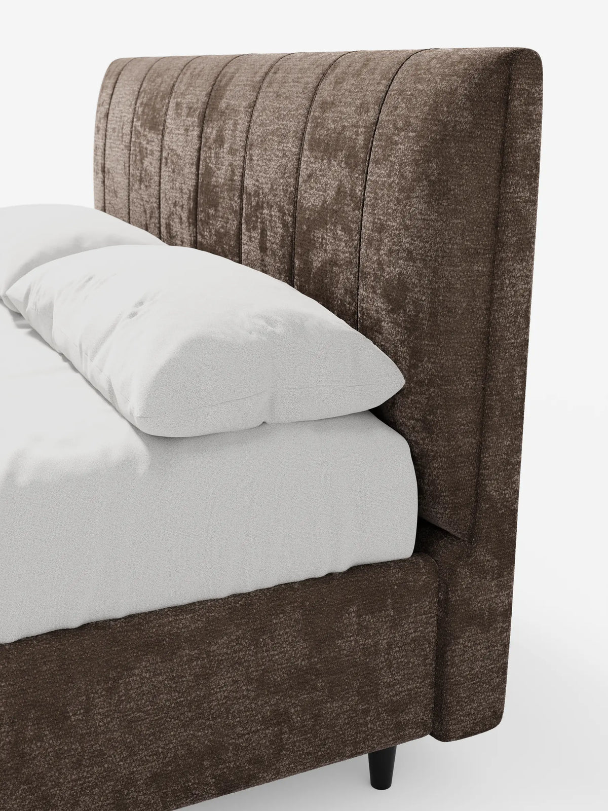 Un primo piano del letto imbottito ONYX con contenitore e testiera verticale in tessuto certificato Oeko-Tex®, caratterizzato da una testiera marrone scuro a pannelli verticali, abbinata a cuscini e lenzuola bianchi su uno sfondo chiaro e uniforme.