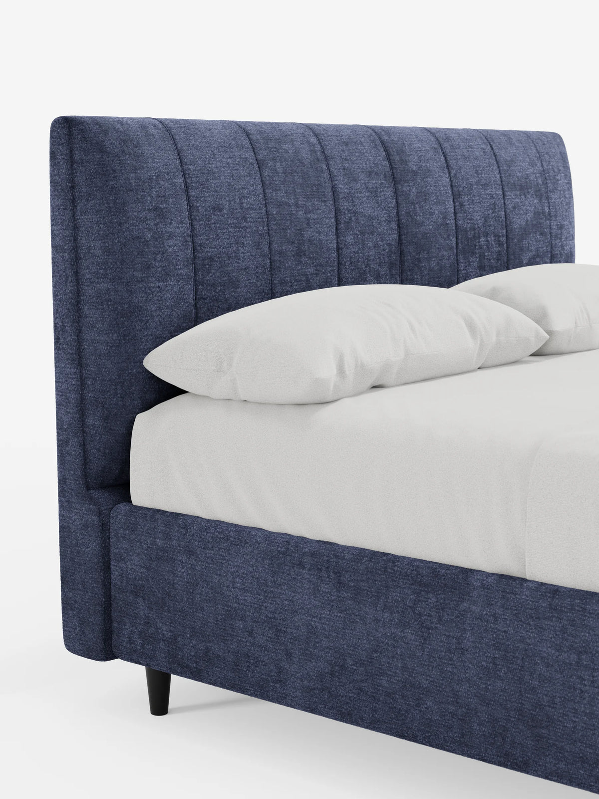 ONYX, letto imbottito con contenitore e testiera verticale in tessuto certificato Oeko-Tex®: un letto imbottito blu navy con una testiera alta e trapuntata verticalmente, rivestito con un lenzuolo bianco e due cuscini, su gambe corte e scure.