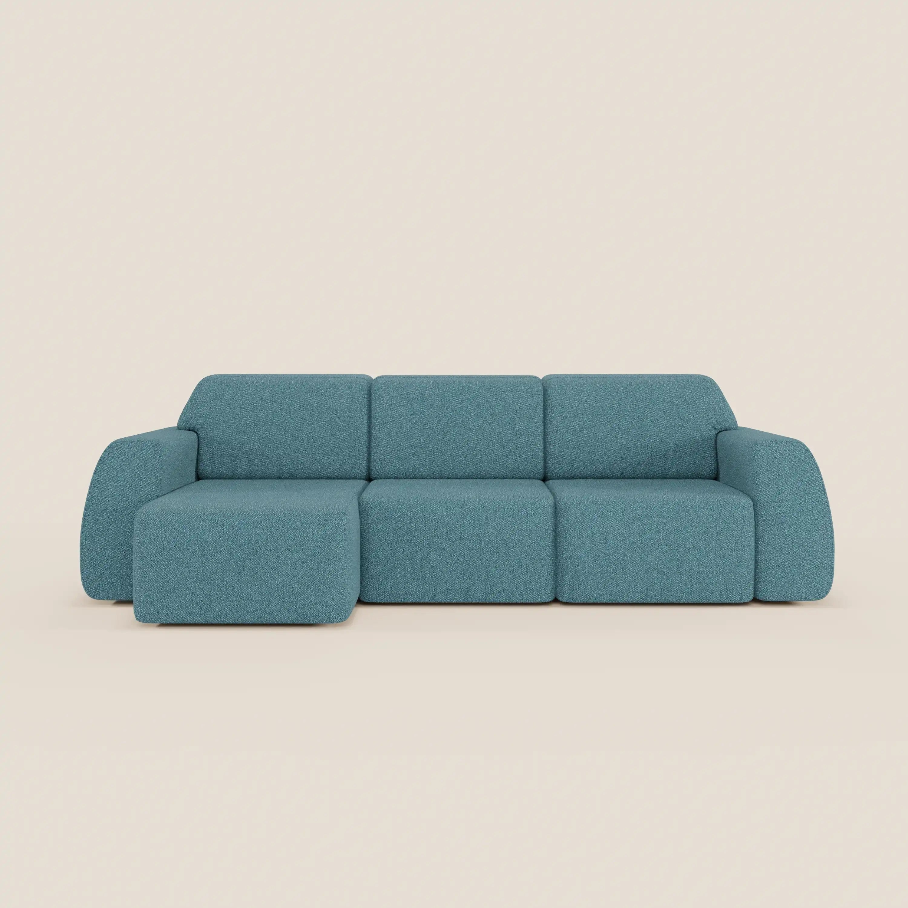 Orbit Divano angolare con penisola reversibile di Divani.Store, in tessuto smacchiabile effetto cotone T33 blu, presenta tre cuscini schienale, sedute allungabili e linee morbide per un look moderno su sfondo beige.