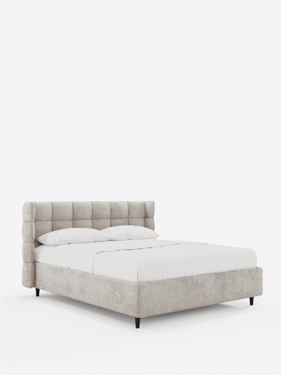 Il letto imbottito RAGNAR con contenitore e testiera capitonné avvolgente è un letto beige con biancheria da letto bianca, caratterizzato da un'alta testiera capitonné con i lati ricurvi e piccoli piedini di colore scuro su sfondo bianco.