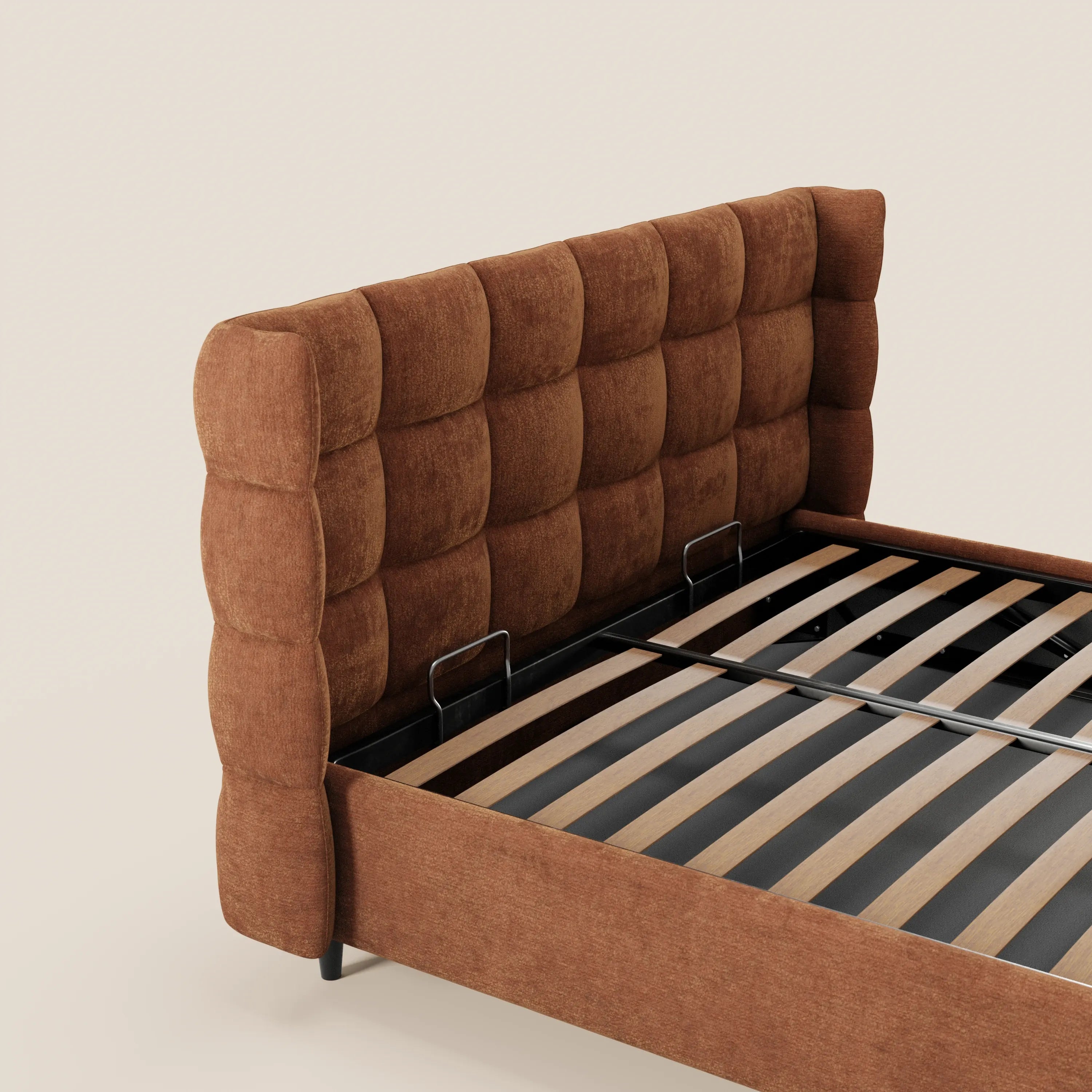 Il letto imbottito RAGNAR di Letti.store presenta una testiera alta e avvolgente con lavorazione capitonné, realizzata in un elegante tessuto color arancio bruciato certificato Oeko-Tex®, bordi arrotondati, gambe corte nere, doghe in legno a vista e un vano contenitore. Sfondo: beige chiaro a tinta unita.