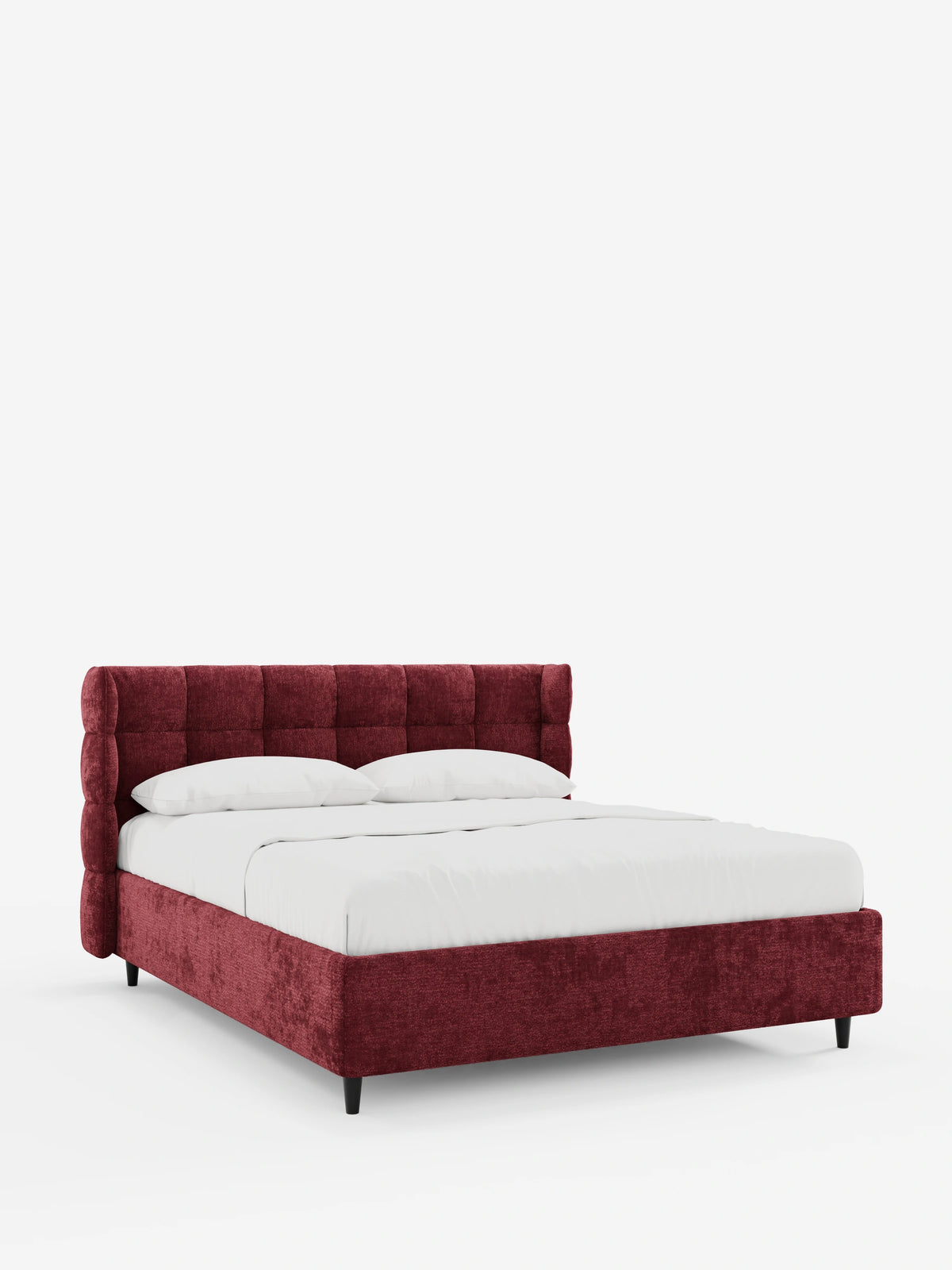Un letto imbottito RAGNAR di colore rosso intenso, dotato di vano contenitore e testiera capitonné avvolgente, spicca su uno sfondo bianco, caratterizzato da una testiera capitonné avvolgente, biancheria da letto candida e gambe corte, scure e slanciate.