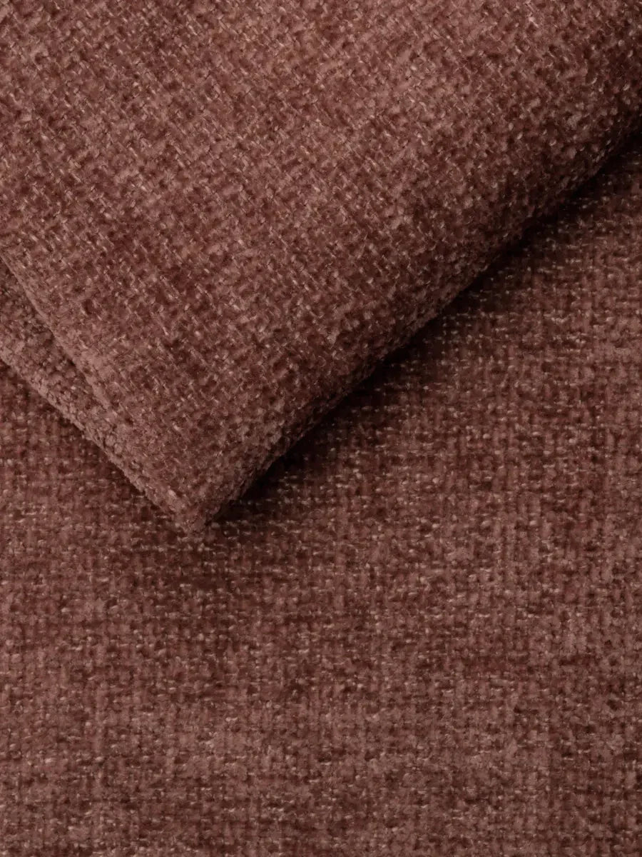 Un primo piano del tessuto materico color terracotta che riveste il divano letto con letto estraibile Ottaviano – penisola reversibile e contenitore in tessuto materico lavabile – che presenta un motivo intrecciato fitto e un angolo ripiegato che conferisce profondità.