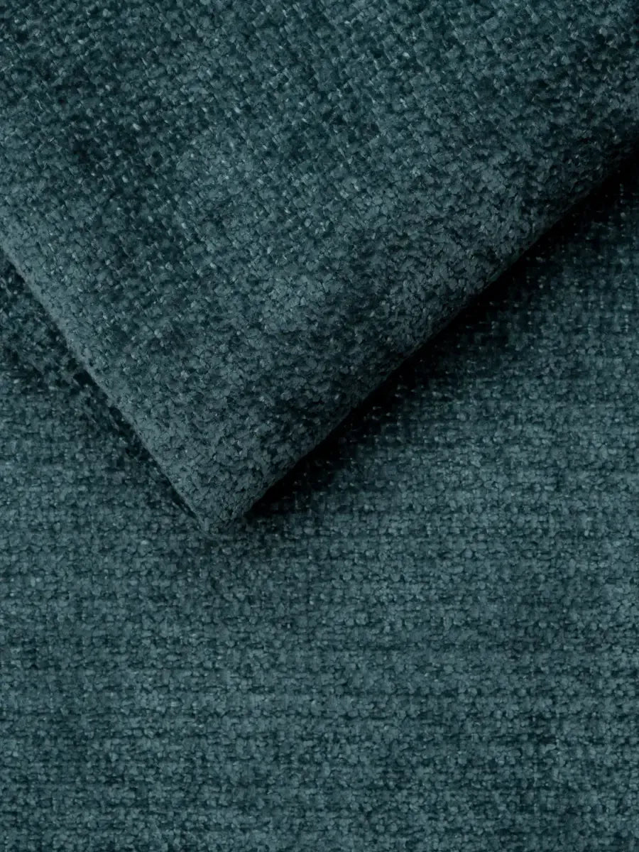 Un primo piano del divano letto Ottaviano con letto estraibile – penisola reversibile e contenitore in tessuto materico smacchiabile, che mostra una trama spessa e scura color verde acqua con un angolo ripiegato che rivela il tessuto denso e granuloso.
