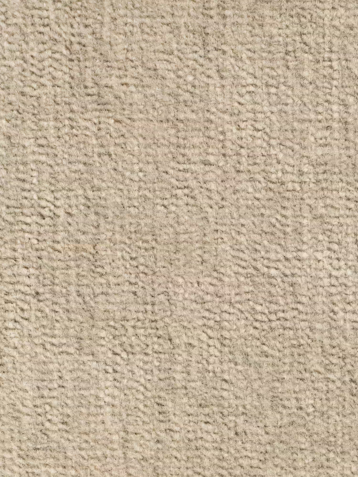 Primo piano di un tappeto beige dalla trama delicata e leggermente ondulata, che si abbina magnificamente al divano Monarch con relax elettrico per l’allungamento delle sedute e poggiatesta reclinabile in tessuto morbido e lavabile T31 di Divani.Store. Il tappeto presenta fibre intrecciate fitto per una superficie uniforme a pelo corto. L’illuminazione è uniforme e sul tappeto non sono visibili macchie, motivi o oggetti.