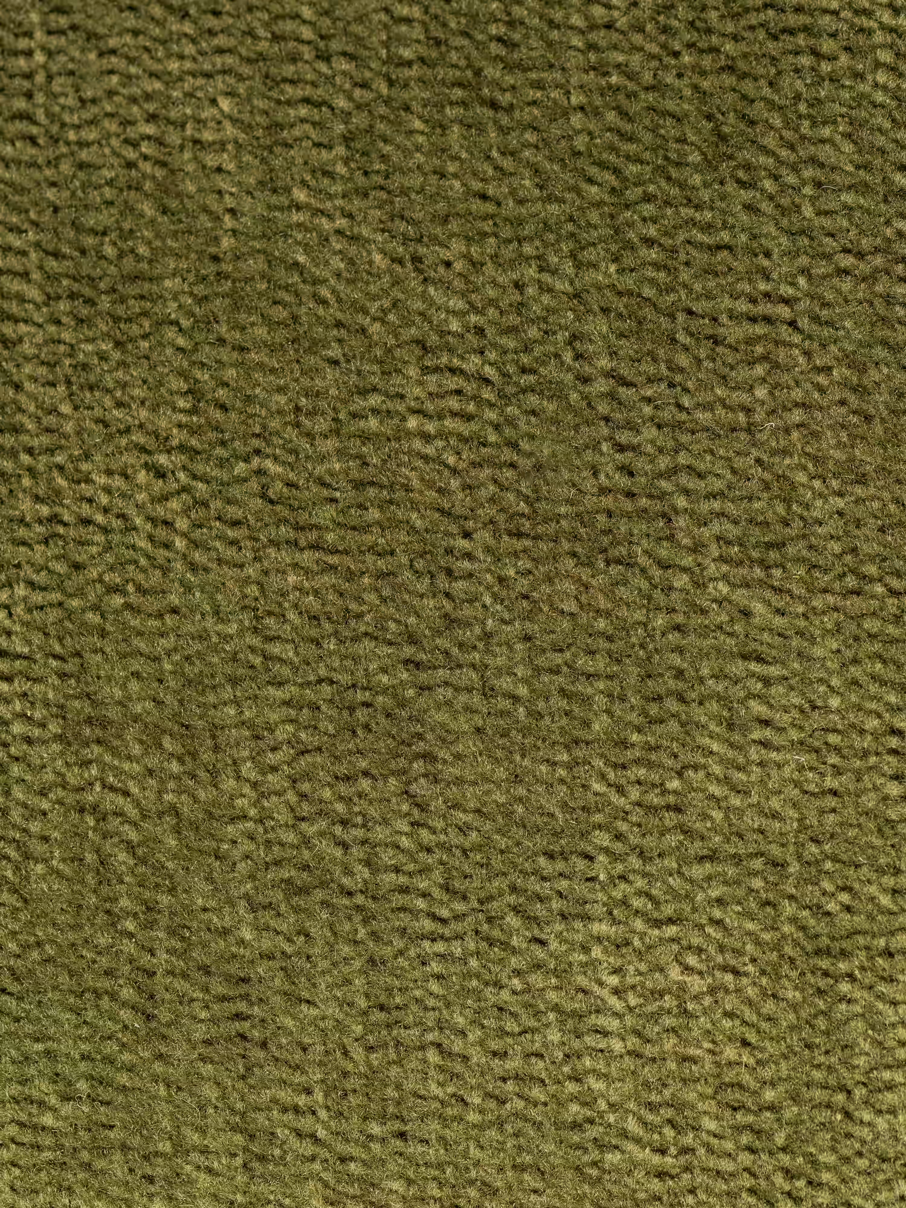 Primo piano sulla superficie in tessuto verde oliva a trama rigata del divano letto matrimoniale Rift a 2 e 3 posti con schienali mobili di Divani.Store. Il materiale presenta linee orizzontali e verticali ben visibili, che creano un effetto leggermente a coste ma morbido, che ricorda il velluto a coste o il velour di alta qualità — ideale per i rivestimenti moderni. La trama morbida e uniforme esalta il comfort del divano letto, valorizzato dal suo materasso in memory foam T31 alto 22 cm.