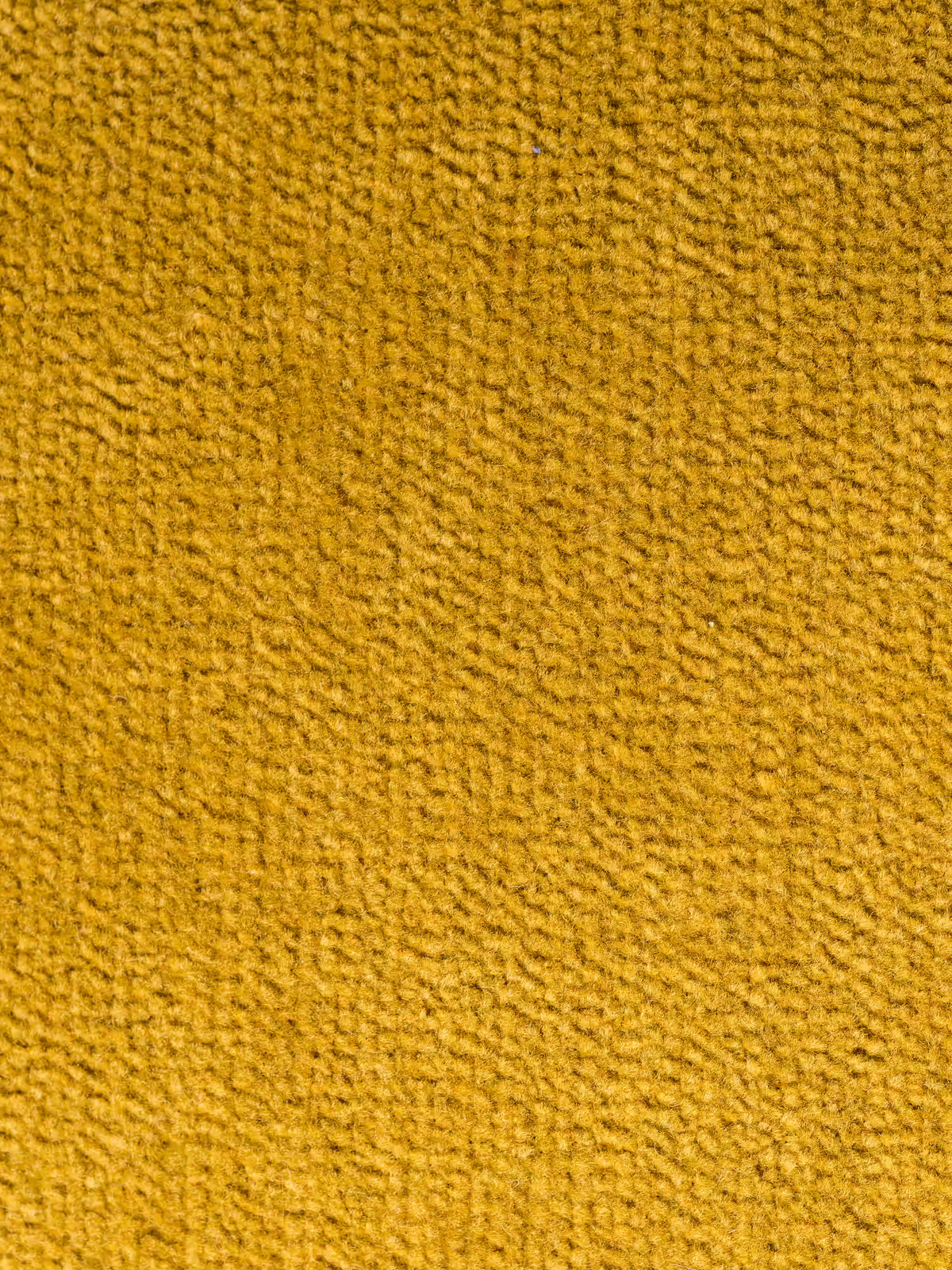 Primo piano di una superficie in morbido tessuto giallo senape T31 resistente alle macchie del modello Monarch Divano con Relax Elettrico per l’allungamento delle sedute e poggiatesta reclinabile di Divani.Store, che mette in risalto un rivestimento testurizzato con piccoli anelli e fibre visibili che creano un motivo delicato e leggermente irregolare. Il colore caldo è uniforme in tutta l’immagine, senza macchie né oggetti visibili.