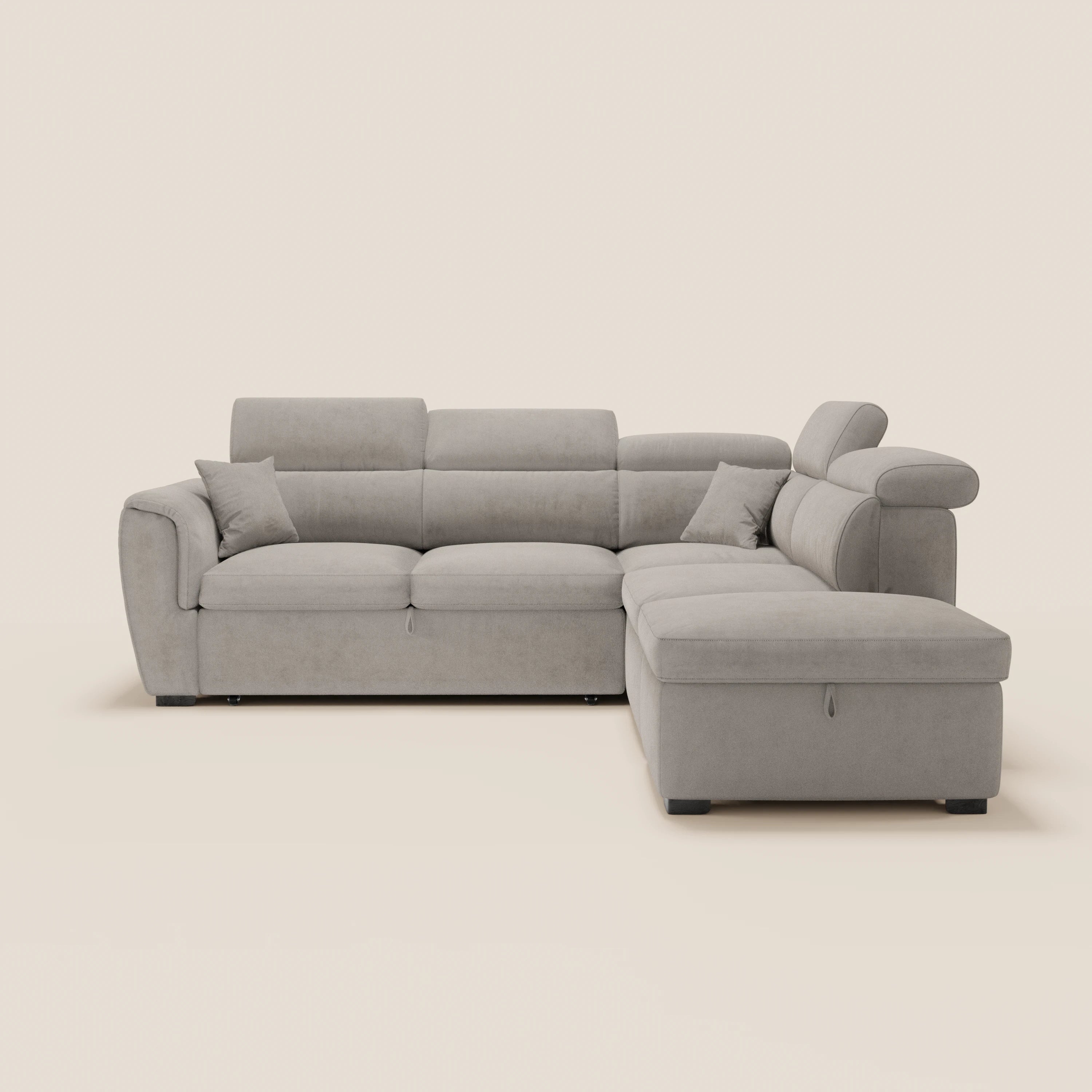 Il divano angolare reversibile Titano di Divani.Store, realizzato in tessuto smacchiabile Oeko-Tex®, è dotato di poggiatesta reclinabili, cassetto estraibile, pouf contenitore e due cuscini su fondo bianco, con piedini neri bassi e un design moderno in grigio chiaro.