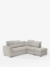 Un divano angolare reversibile Titano, rivestito in grigio chiaro, con seduta estraibile e pouf contenitore di Divani.Store, è posizionato su uno sfondo bianco a tinta unita. Questo moderno divano componibile è dotato di morbidi cuscini, poggiatesta reclinabili in tessuto smacchiabile certificato Oeko-Tex®, una chaise longue integrata, schienali trapuntati e piedini neri bassi che ne garantiscono comfort e versatilità.