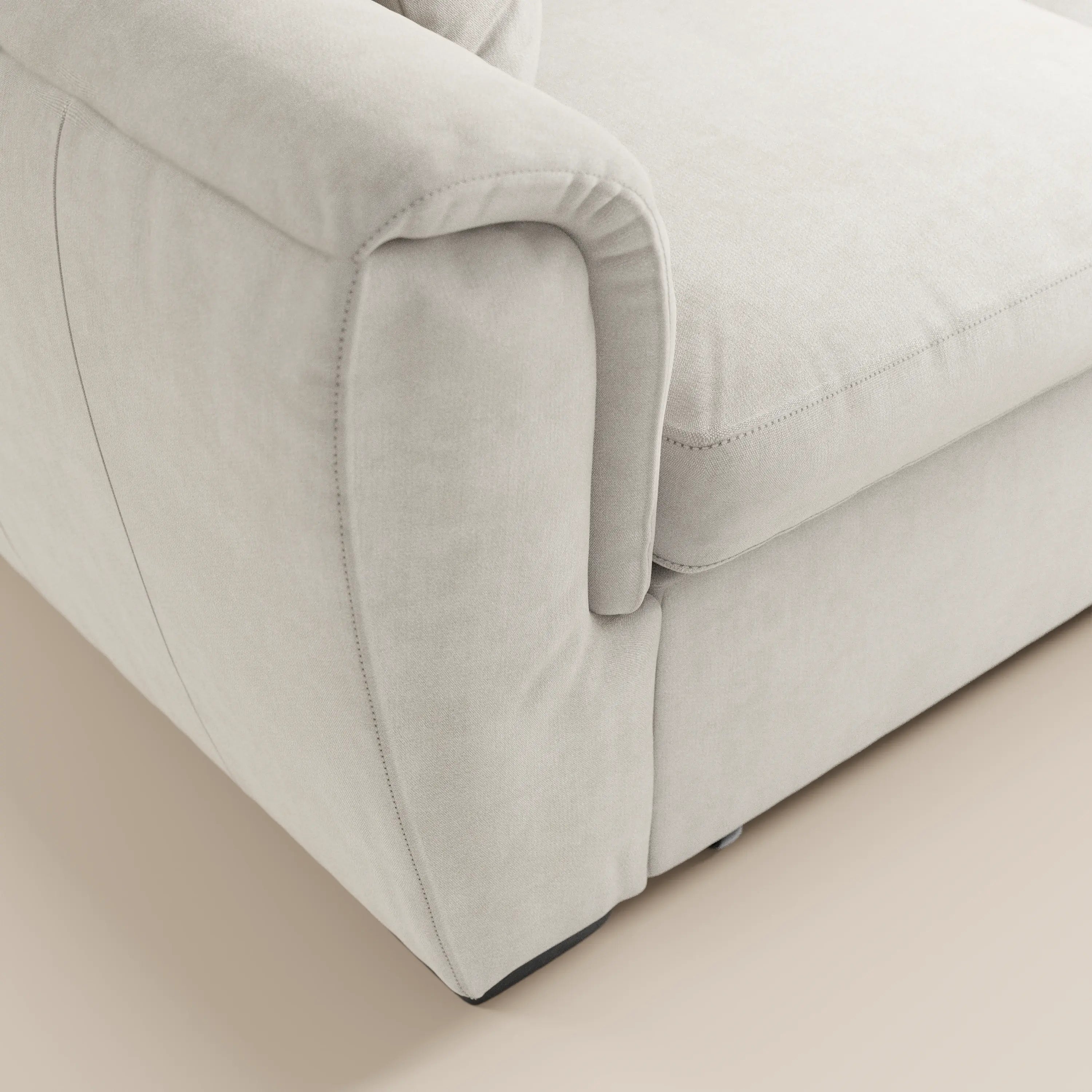 Primo piano del divano a 2 posti estraibile Titano con poggiatesta reclinabili in tessuto smacchiabile Oeko-Tex® di Divani.Store, che mette in risalto i braccioli, il cuscino della seduta e lo schienale con cuciture a vista su uno sfondo chiaro.