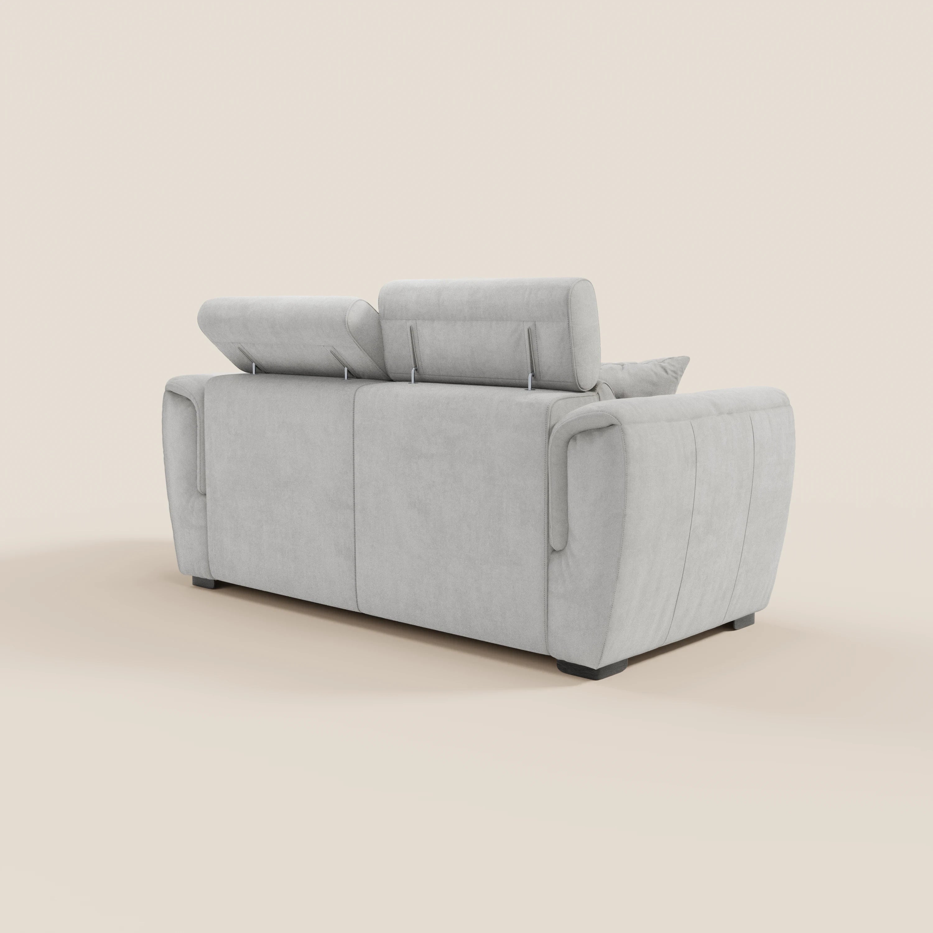 Il divano a 2 posti estraibile Titano di Divani.Store, raffigurato di retro e di profilo, presenta poggiatesta reclinabili, tessuto smacchiabile certificato Oeko-Tex®, ampi braccioli, imbottitura morbida e piedini neri corti su uno sfondo beige.