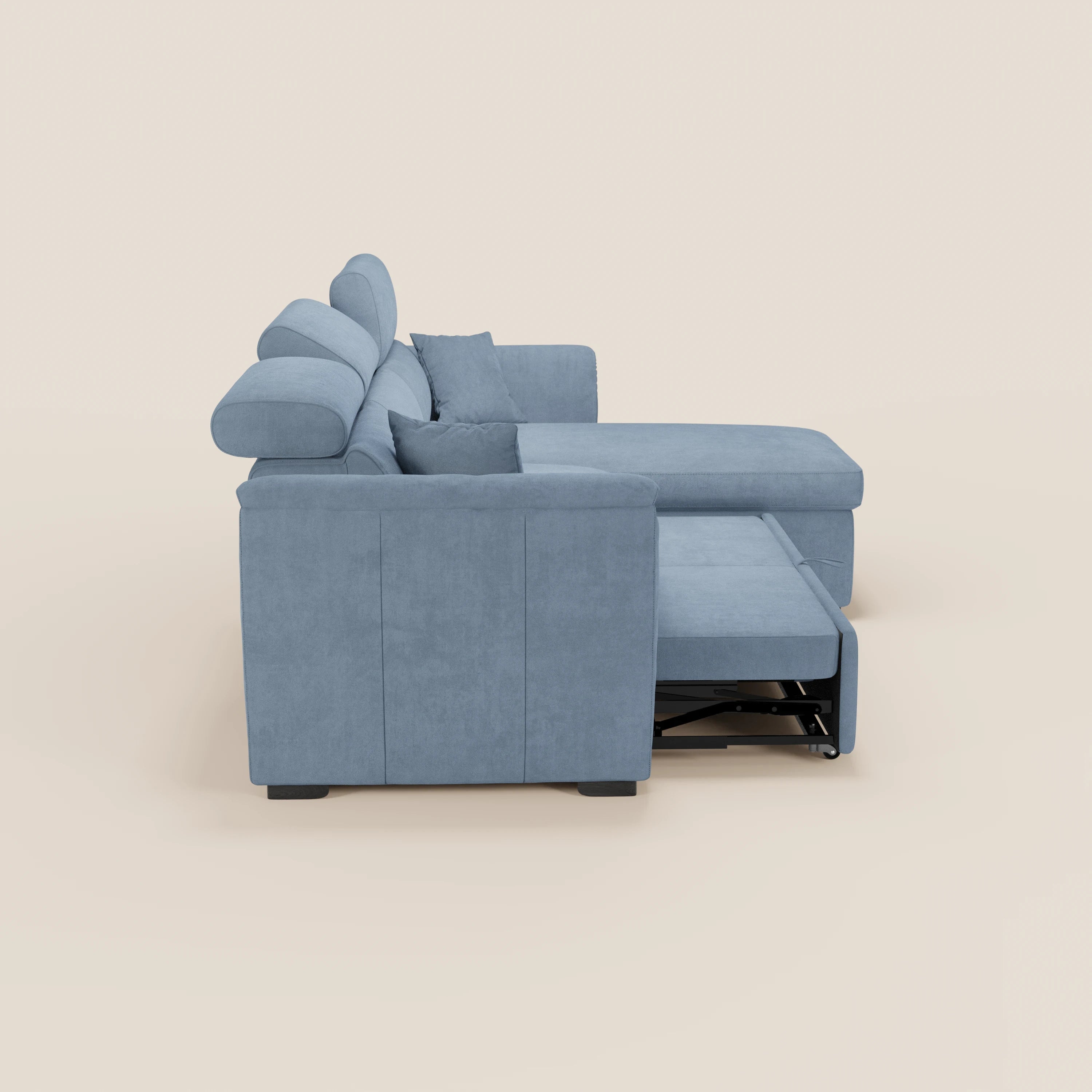 Il divano letto Titano con penisola reversibile di Divani.Store, in tessuto smacchiabile azzurro, con poggiatesta reclinabili, contenitore ed elemento estraibile, è raffigurato di profilo su uno sfondo beige con cuscini e braccioli imbottiti, per un look moderno.