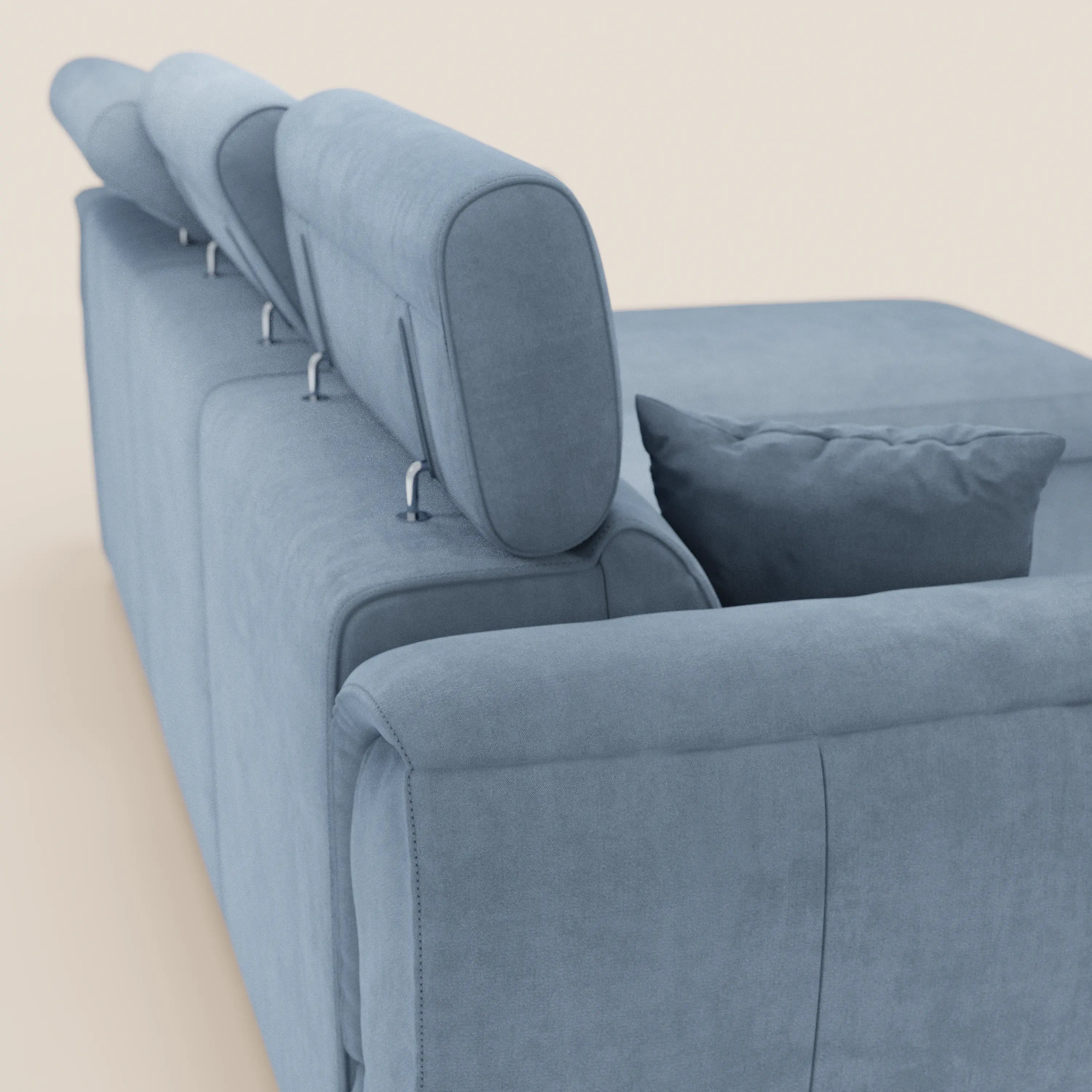 Un primo piano del divano letto Titano di Divani.Store in azzurro, dotato di poggiatesta reclinabili, penisola reversibile con contenitore, elemento estraibile e tessuto smacchiabile su sfondo neutro.