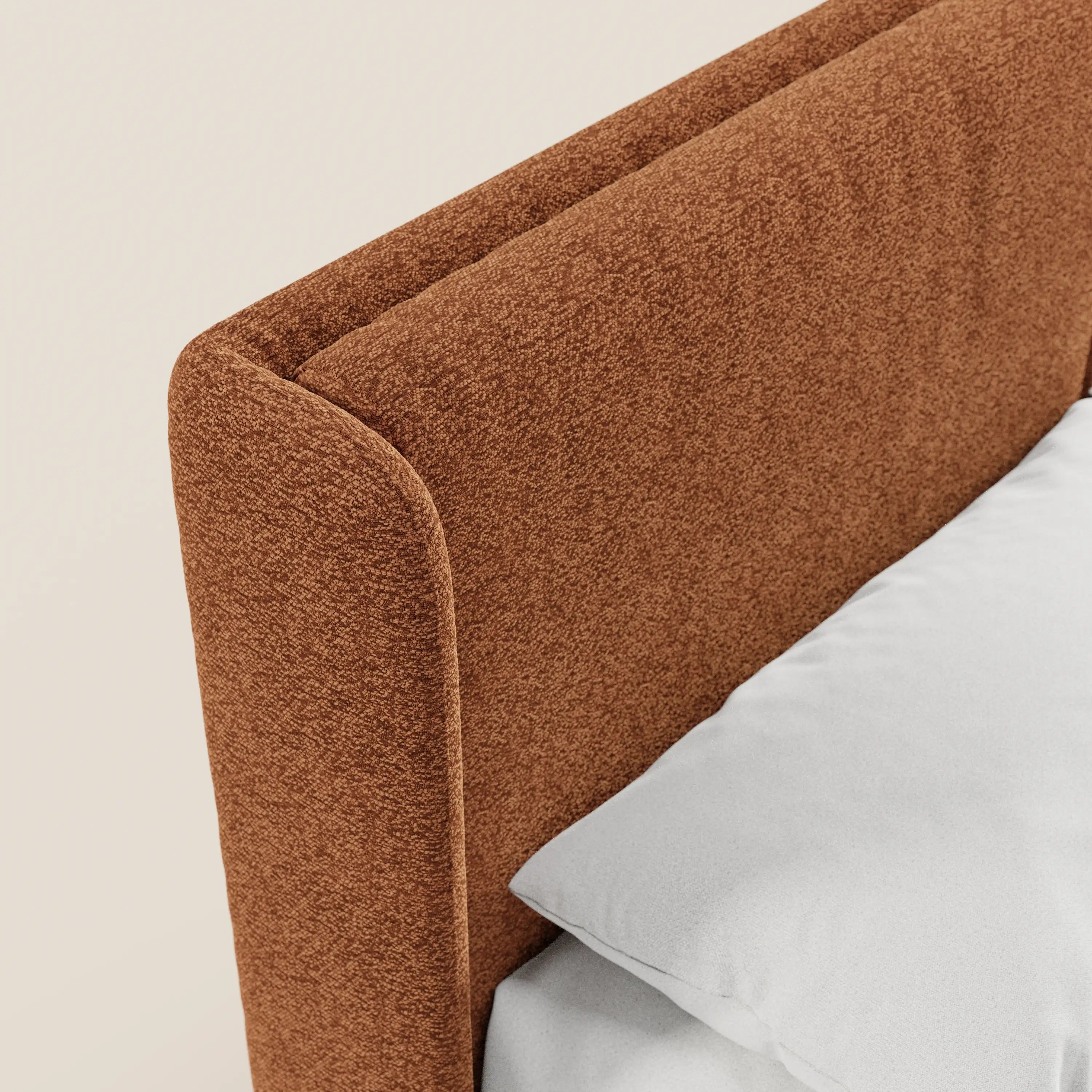 Primo piano del letto di design VALKIRIA di Letti.store, che mette in risalto la testiera con finitura effetto ruggine certificata Oeko-Tex® e la base contenitiva. Il cuscino bianco e la biancheria da letto esaltano il contrasto, perfetto per una camera da letto dal design contemporaneo. È dotato di 2 cuscini imbottiti e di una testiera avvolgente.