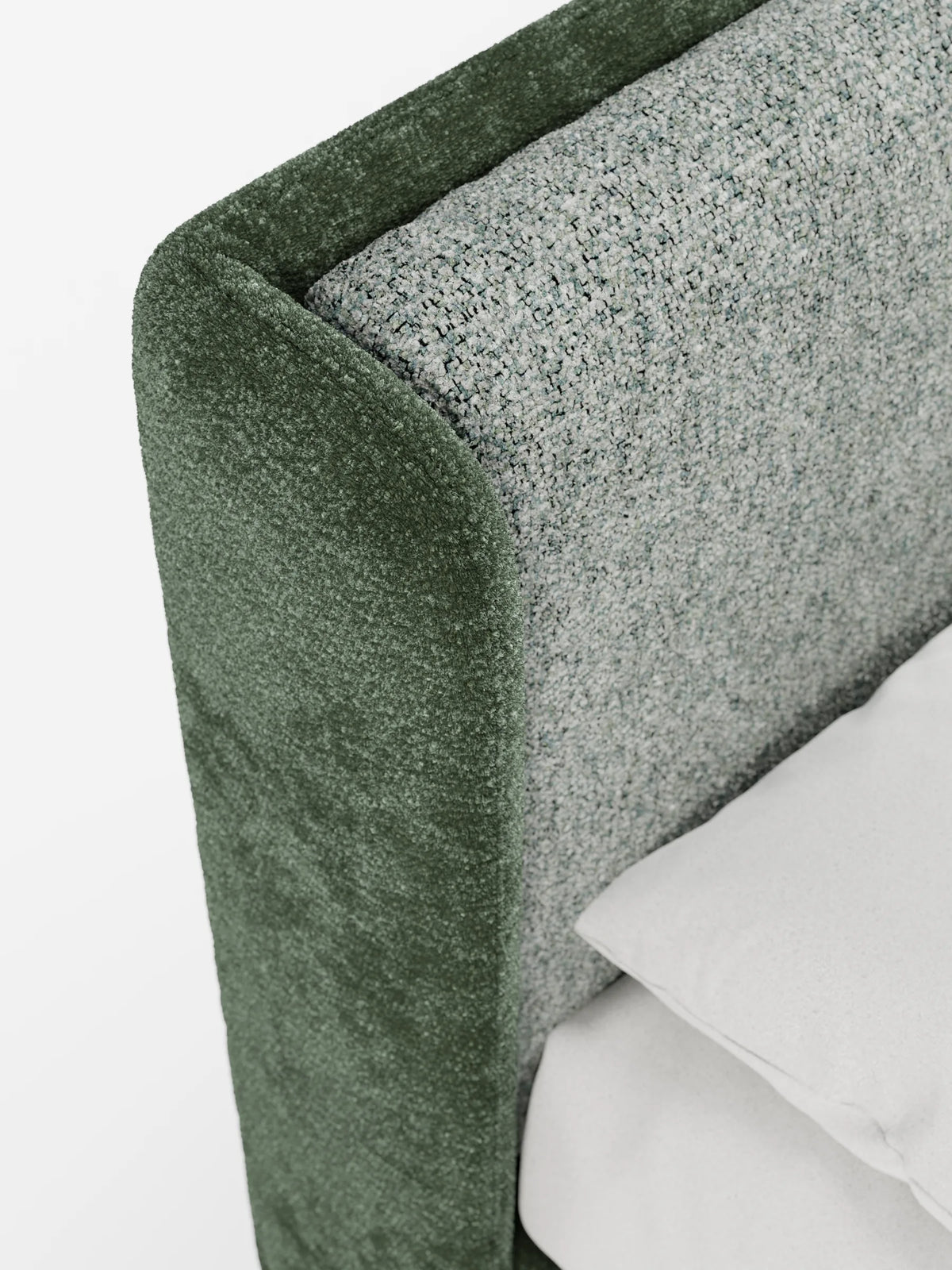 Un primo piano del divano letto VALKIRIA bicolore con contenitore, dalle linee curve, caratterizzato da un rivestimento esterno verde bosco intenso, un pannello interno grigio chiaro screziato e un cuscino bianco a tinta unita.