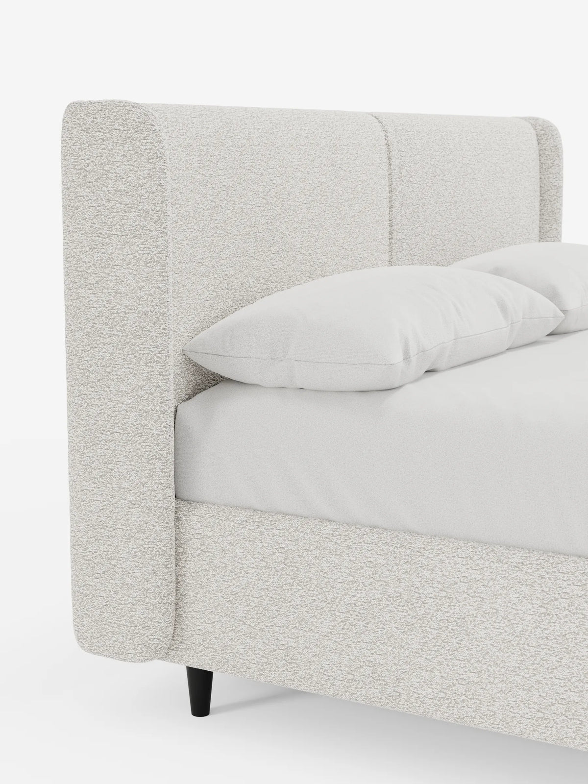 VALKIRIA, letto di design con contenitore e testiera avvolgente, è un letto contemporaneo caratterizzato da un'alta testiera avvolgente in tessuto color crema, rivestito con lenzuola bianche e due morbidi cuscini, su gambe minimaliste di colore scuro che risaltano sullo sfondo bianco.