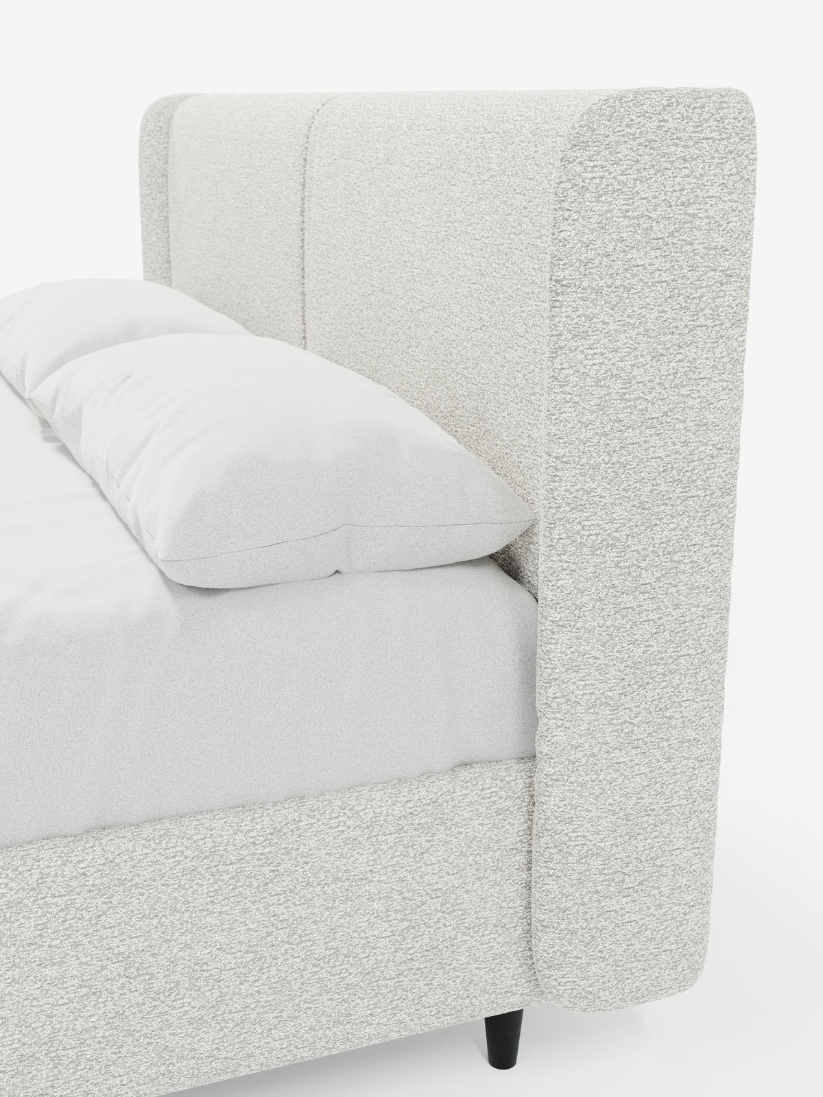 Un primo piano del letto di design VALKIRIA con vano contenitore e testiera avvolgente di Letti.store, caratterizzato da un’alta testiera imbottita di colore grigio chiaro e da pannelli laterali. Questo letto imbottito in stile contemporaneo presenta biancheria da letto bianca, due cuscini imbottiti certificati Oeko-Tex® e gambe corte nere, il tutto su uno sfondo bianco a tinta unita.