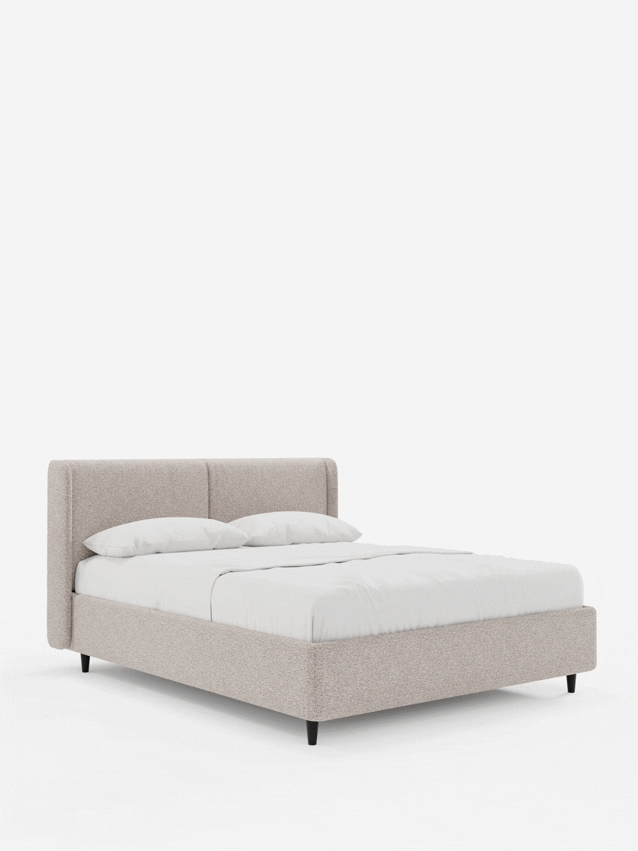 Il letto di design VALKIRIA con contenitore e testiera avvolgente è un letto matrimoniale contemporaneo con struttura in tessuto beige chiaro e testiera avvolgente, rivestito con lenzuola bianche, poggiato su gambe corte nere affusolate su uno sfondo bianco.