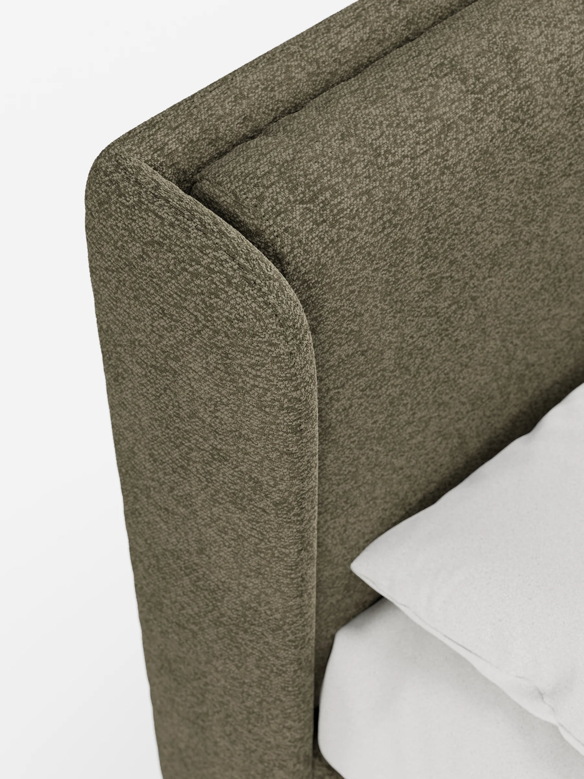 Un primo piano del letto di design VALKIRIA con contenitore e testiera avvolgente, caratterizzato da una testiera curva, di colore verde oliva e dalla superficie ruvida, su cui sono disposti due morbidi cuscini bianchi, impilati con cura.
