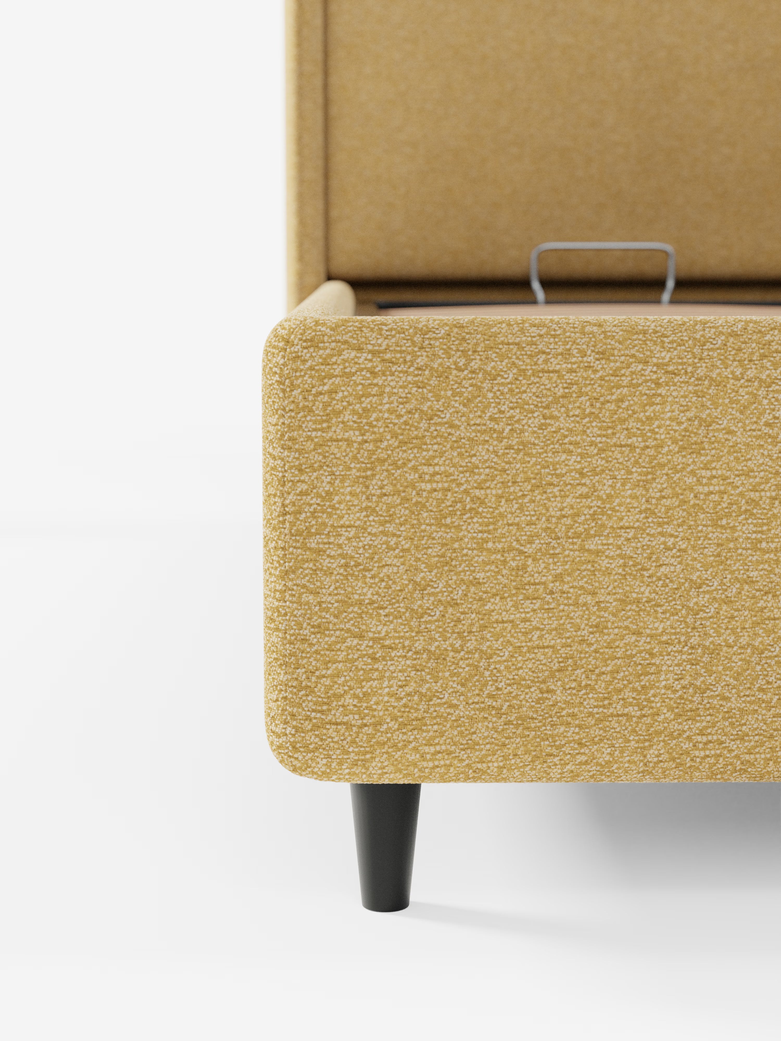 Primo piano del letto di design VALKIRIA di Letti.store, caratterizzato da un tessuto testurizzato giallo senape certificato Oeko-Tex®, gambe affusolate in legno nero e una maniglia in metallo a vista sul vano portaoggetti interno. La testiera avvolgente con due cuscini imbottiti risalta sullo sfondo bianco: un’elegante espressione del design contemporaneo per interni moderni.
