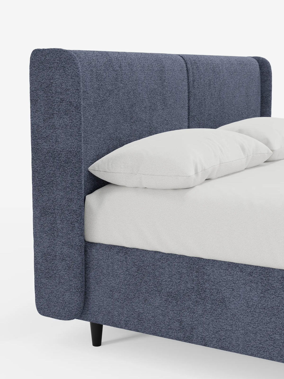 VALKIRIA, letto di design con contenitore e testiera avvolgente, caratterizzato da una struttura imbottita blu con effetto materico e da un’alta testiera avvolgente; due cuscini bianchi poggiano su un materasso bianco immacolato, su uno sfondo grigio chiaro.