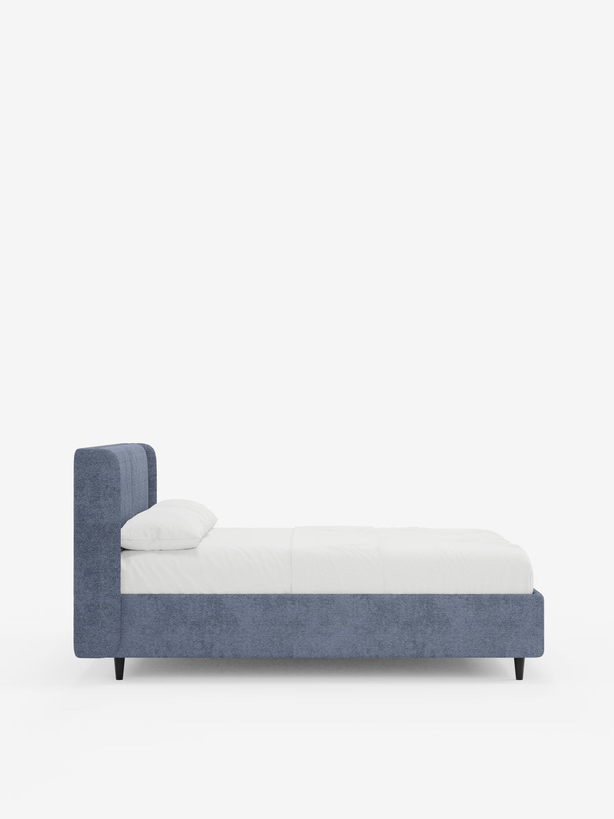 Una vista laterale del letto di design VALKIRIA con vano contenitore e testiera avvolgente di Letti.store, caratterizzato da una struttura rivestita in tessuto azzurro certificato Oeko-Tex® con gambe corte nere, un materasso bianco e due cuscini imbottiti, il tutto su uno sfondo bianco a tinta unita per esaltarne il design elegante e contemporaneo.