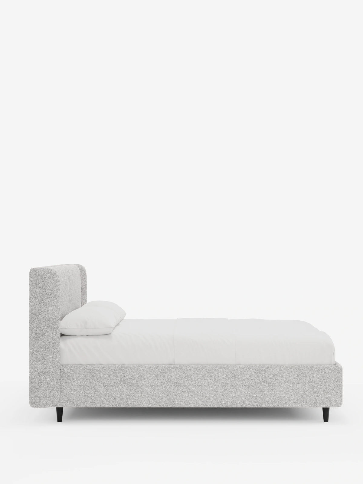 Vista laterale di un letto di design VALKIRIA con contenitore e testiera avvolgente in grigio chiaro, caratterizzato da un’alta testiera avvolgente, biancheria da letto bianca con due cuscini e gambe affusolate nere su uno sfondo bianco uniforme.