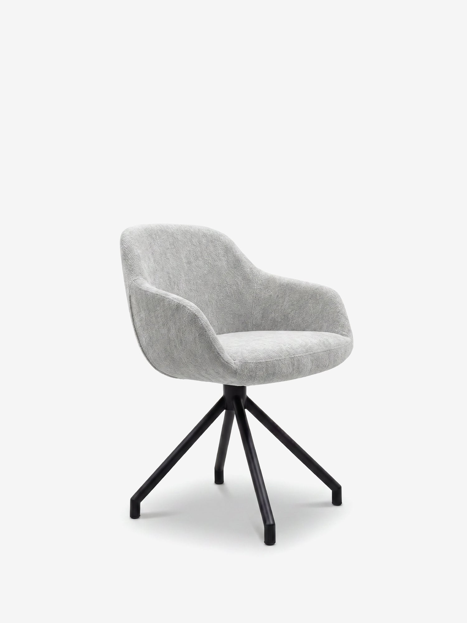 La sedia imbottita Vico di Divani.Store è caratterizzata da un tessuto grigio chiaro morbido al tatto certificato OEKO-TEX®, uno schienale curvo con braccioli e una raffinata base a quattro gambe in metallo nero con gambe divaricate verso l’esterno, il tutto su uno sfondo bianco a tinta unita.