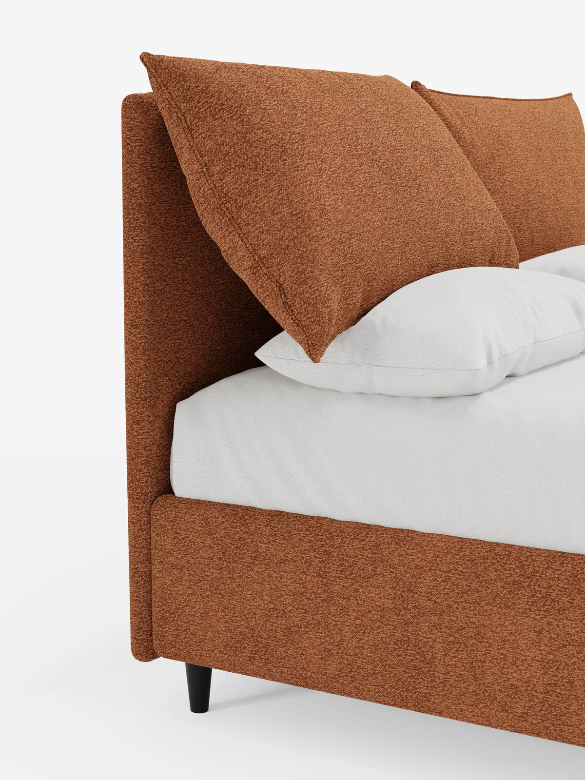 ZAYRON, letto imbottito con contenitore e morbidi cuscini regolabili: una moderna struttura da letto in tessuto arancione bruciato con texture, dotata di ampi cuscini schienali, biancheria da letto bianca e sottili gambe nere su uno sfondo bianco a tinta unita.