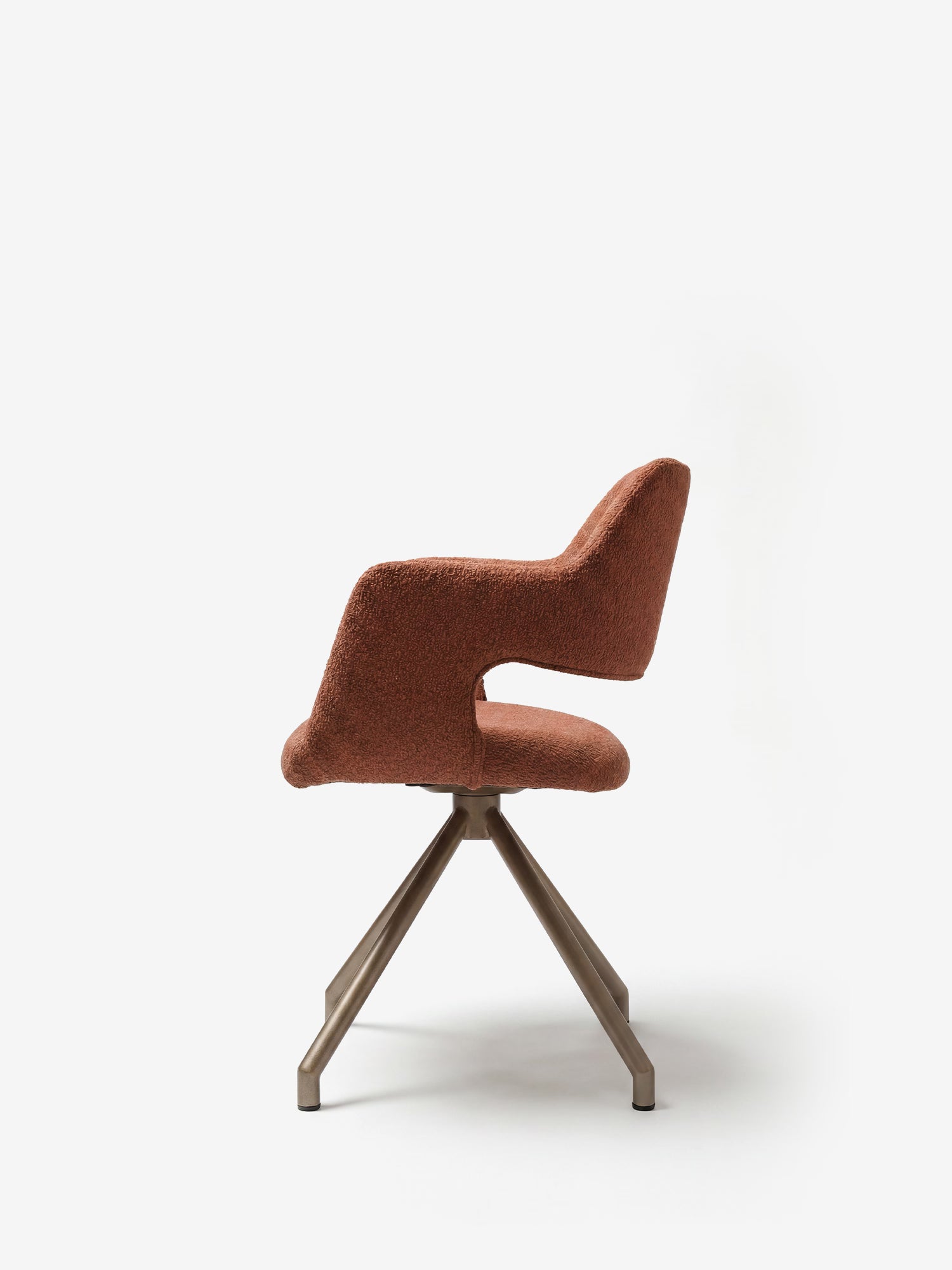 La sedia imbottita di design Zefira con braccioli di Divani.Store è caratterizzata da un tessuto con effetto cotone a trama in arancione ruggine e da una sede dalla forma distintamente curva, poggiata su una base metallica a quattro gambe color champagne, che risalta sullo sfondo bianco a tinta unita.