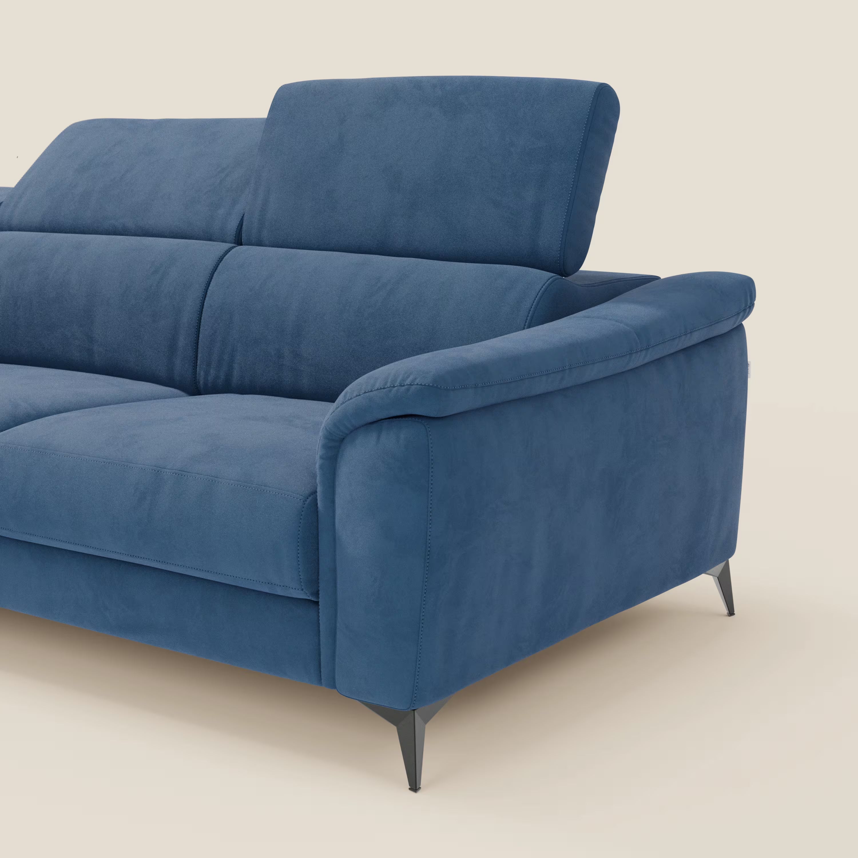 Arcos Divano con penisola di Divani.Store, in microfibra T11 blu impermeabile, è caratterizzato da cuscini morbidi, un unico poggiatesta regolabile, braccioli imbottiti e arrotondati e sottili gambe nere. Solo il lato destro è mostrato su uno sfondo beige.