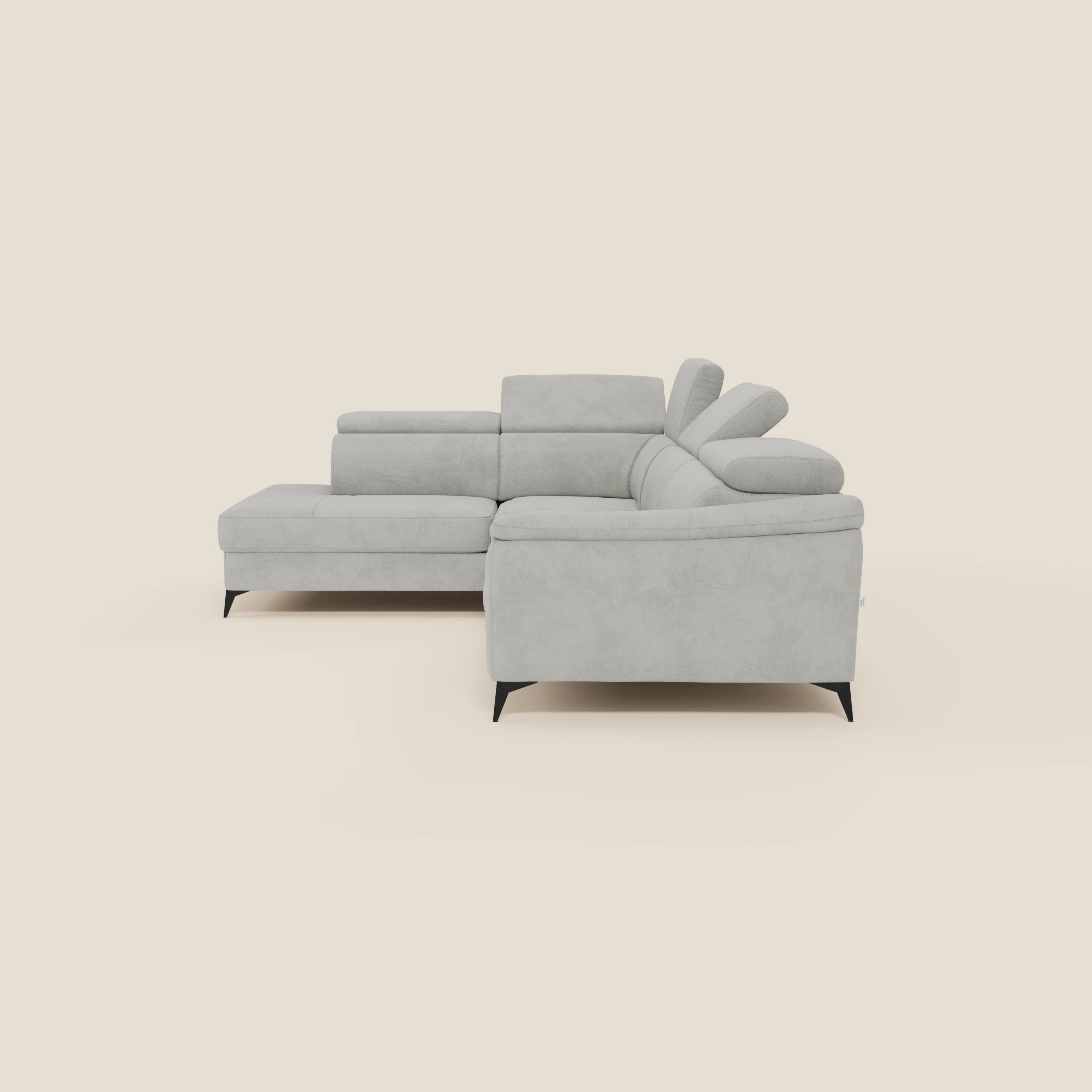 Arcos Divano angolare di Divani.Store è caratterizzato da alte gambe nere, linee pulite e poggiatesta regolabili in microfibra impermeabile T11 grigio chiaro, raffigurati su uno sfondo tinta unita crema con un poggiatesta parzialmente sollevato.