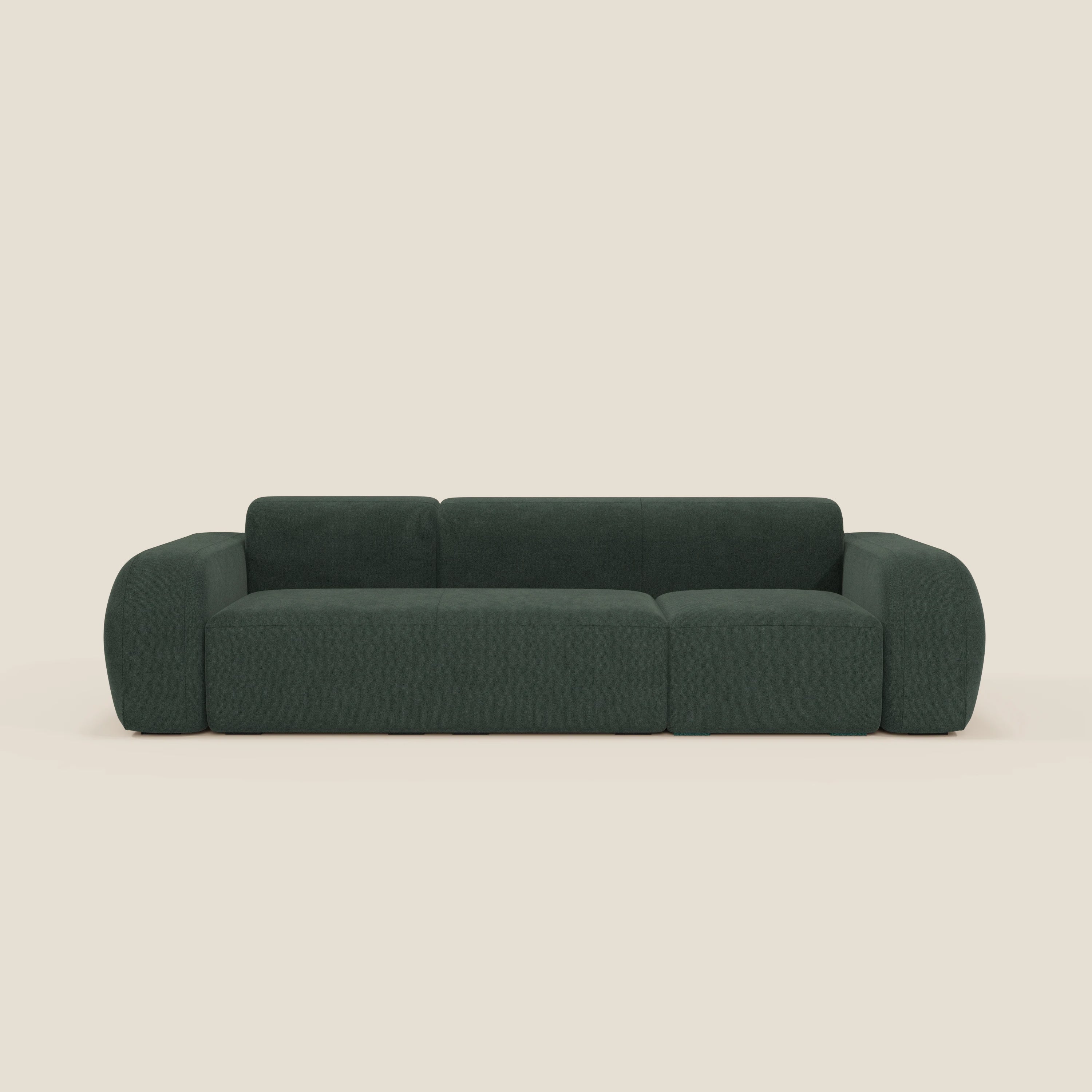 Il BonBon Divano componibile di Divani.Store in smacchiabile T23 verde è caratterizzato da braccioli ampi e arrotondati e da un profilo basso. Il suo design minimalista e felpato crea un look accogliente e contemporaneo su uno sfondo beige chiaro.