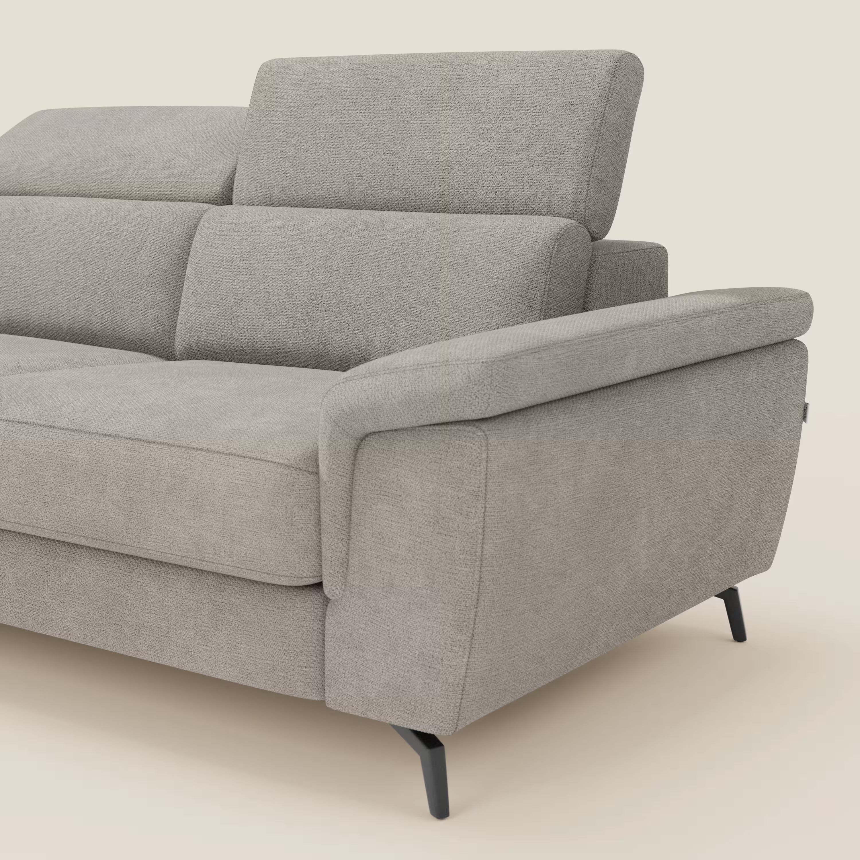 Estro Divano estraibile contemporaneo di Divani.Store in tessuto impermeabile T14 tortora, con chaise-longue, poggiatesta regolabili, ampi braccioli e sottili gambe nere. Le linee pulite e la texture morbida sono visibili su uno sfondo beige. Viene mostrata solo una parte.