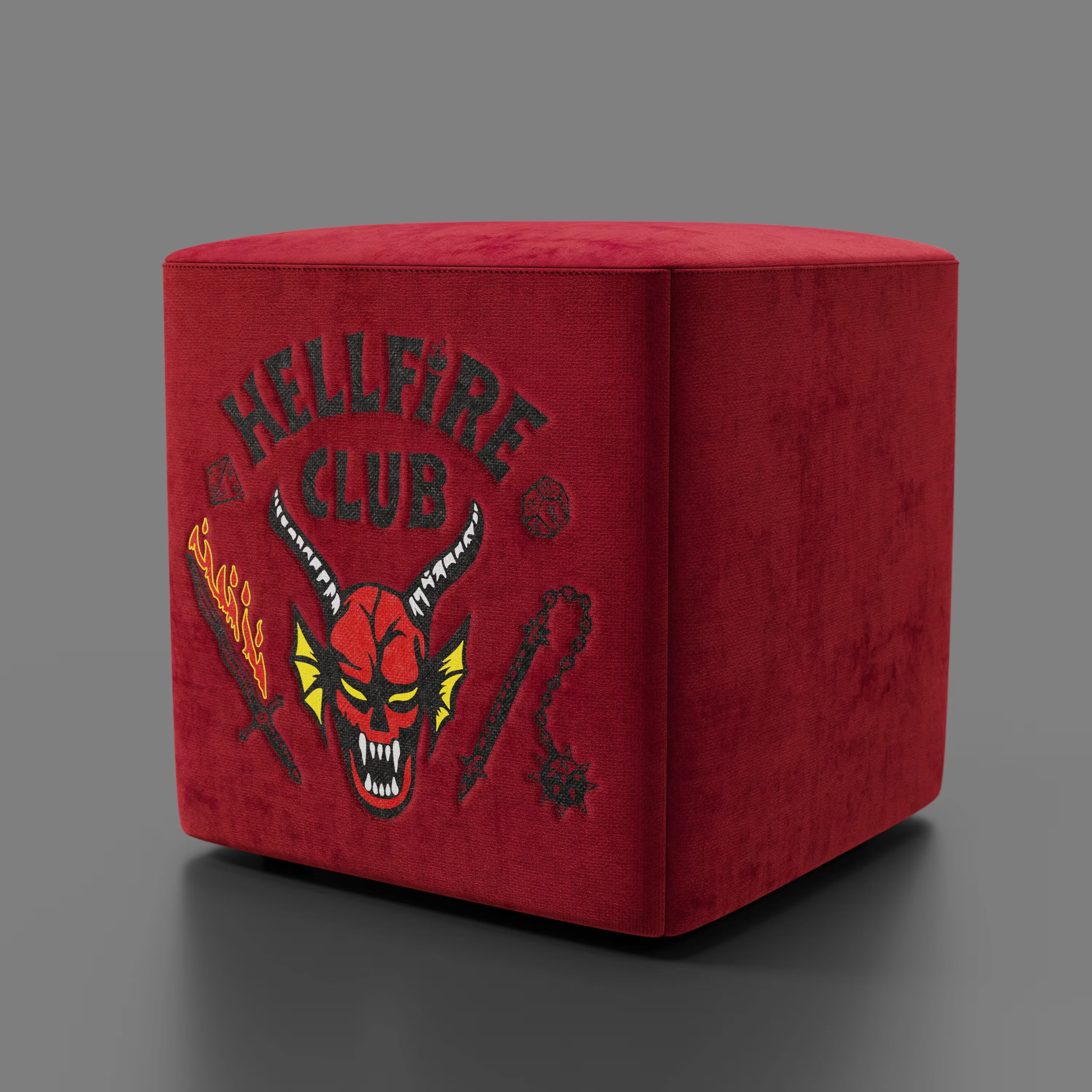 Il pouf Cube Hellfire club Stranger Things Edition di Divani.Store è caratterizzato da un audace ricamo su velluto rosso, che trasforma questo pouf artigianale in una sorprendente dichiarazione di design.