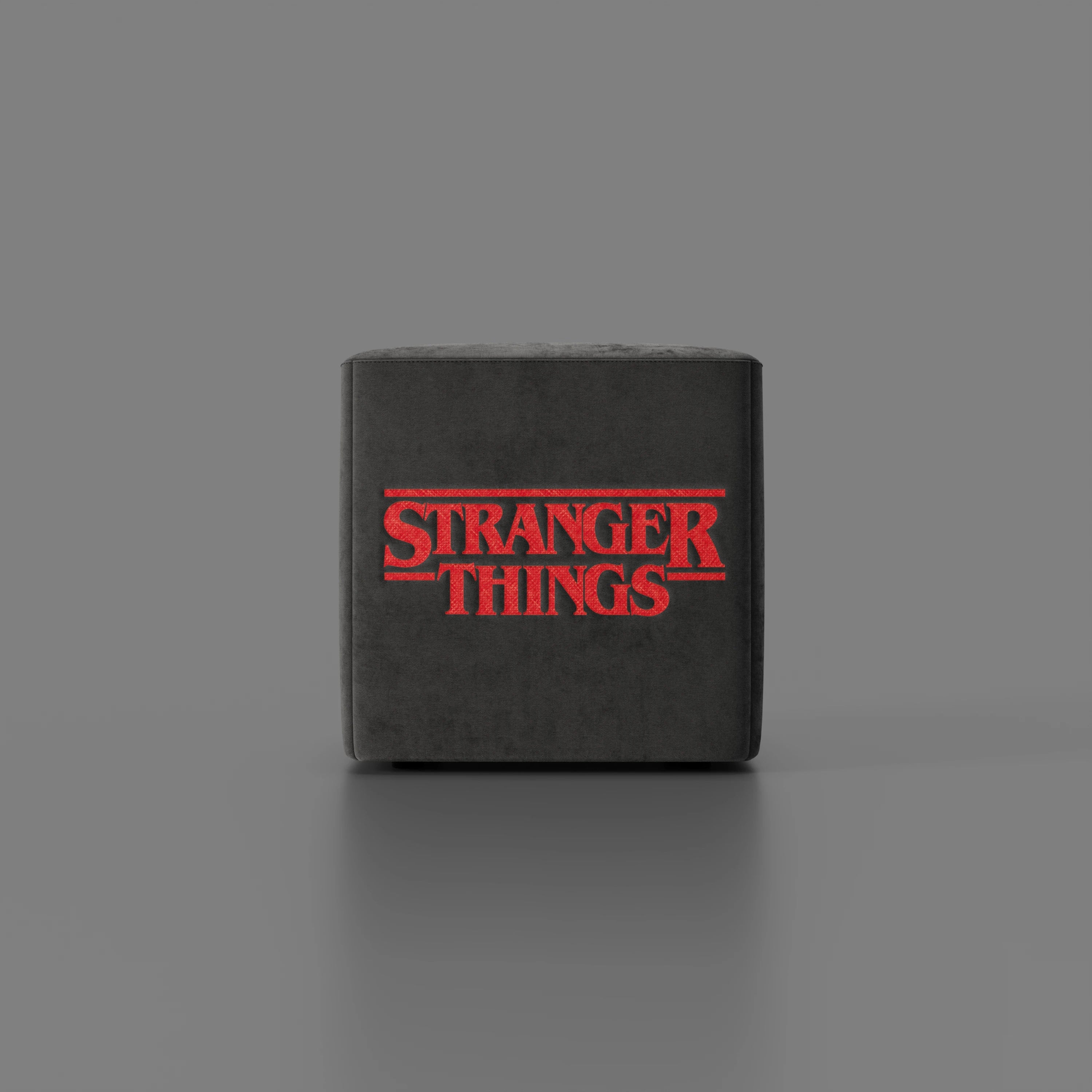 Il pouf Cube Stranger Things Edition di Divani.Store è caratterizzato da un tessuto antracite antimacchia e da un logo retrò sulla parte anteriore, che unisce un design unico a uno stile leggendario, perfetto per i fan in cerca di un arredamento di spicco.