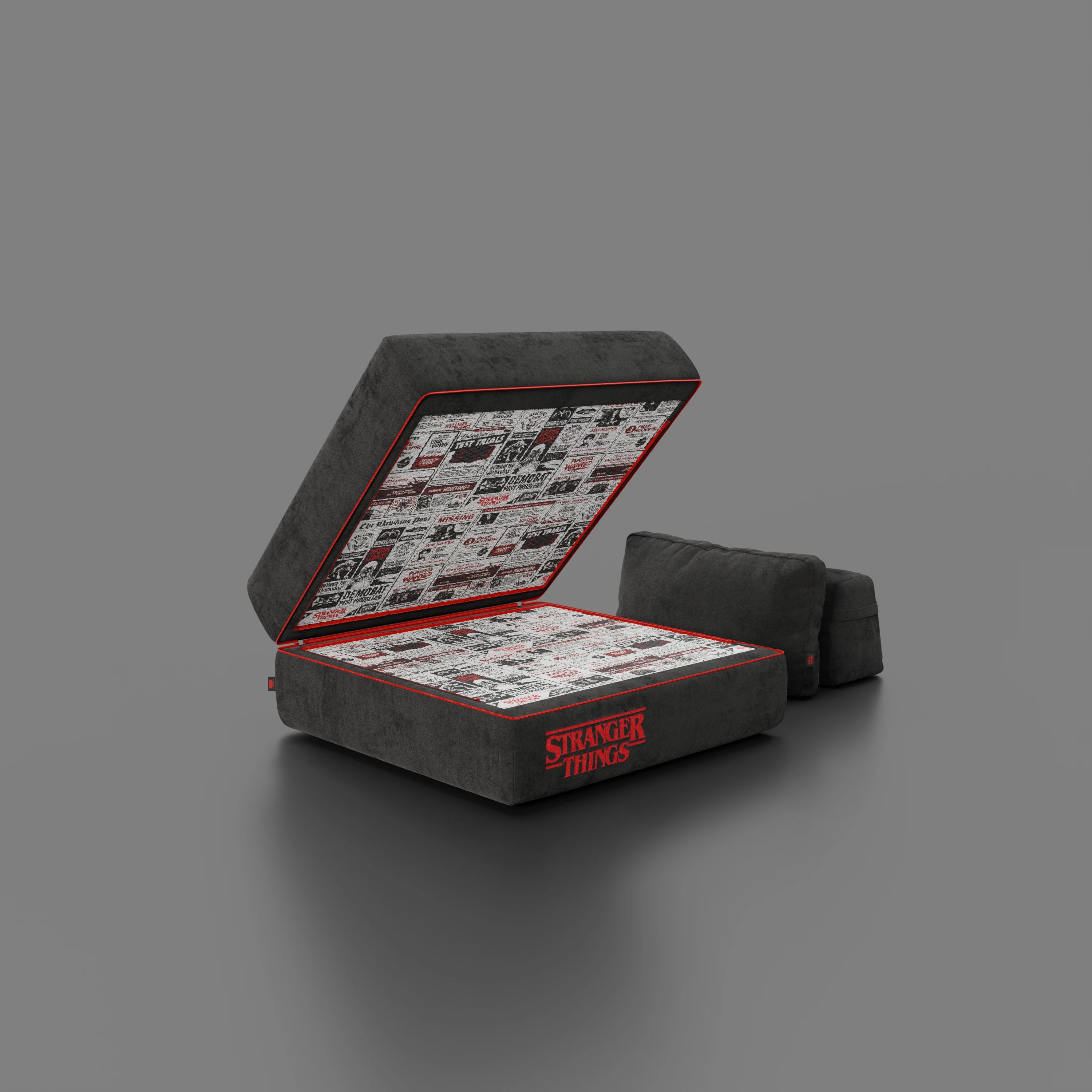 La poltrona letto Rift STRANGER THINGS Edition di Divani.Store è caratterizzata da un tessuto antracite antimacchia, da un materasso in memory foam alto 22 cm e da un interno foderato di fumetti, il tutto su un semplice sfondo grigio.