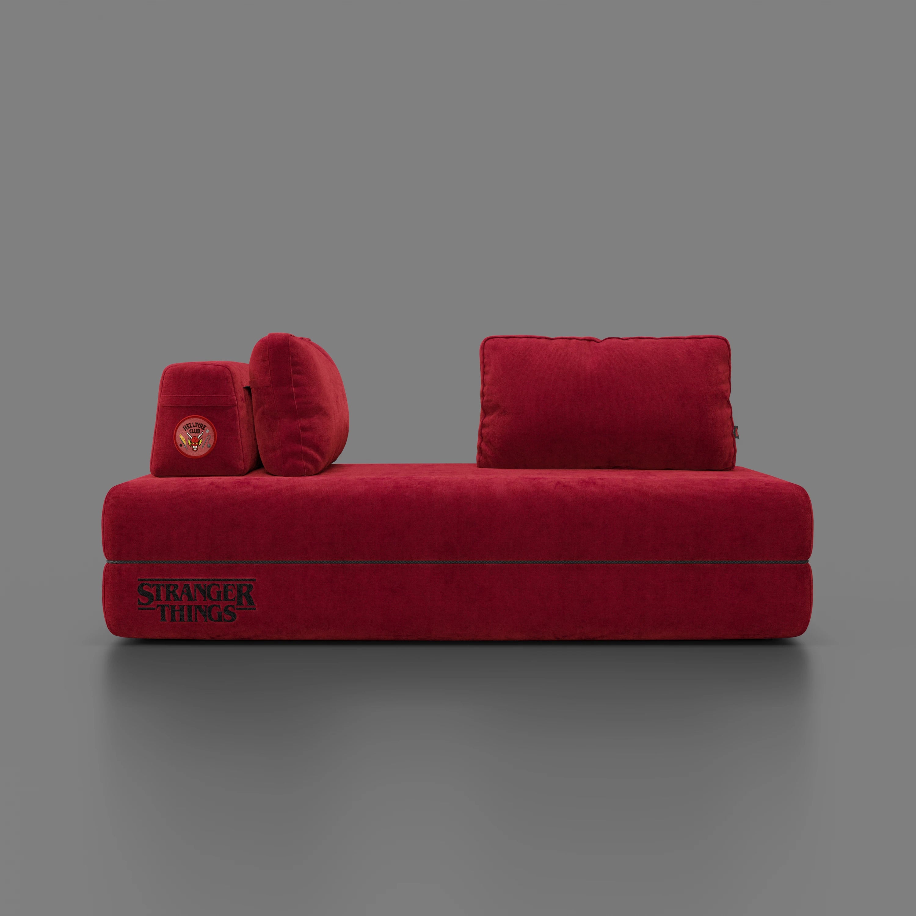 Il divano letto matrimoniale Rift STRANGER THINGS Edition di Divani.Store è un moderno divano rettangolare rosso con schienali mobili, due o tre posti, tessuto lavabile, materasso in memory foam (22 cm) e ricamo a tema, su sfondo grigio tinta unita.